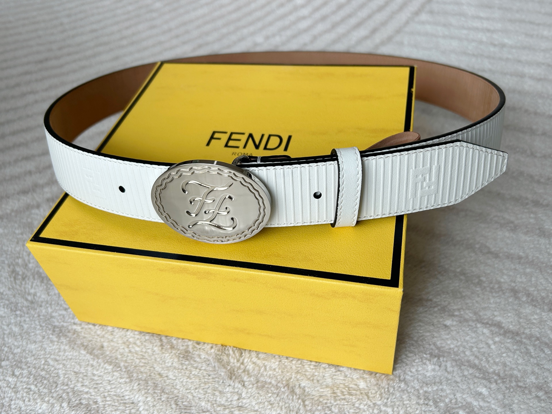  FENDI (芬迪) 男款休闲腰带 宽3.4cm 白色粒面牛皮材质，饰有FF图案和凸纹天然橡胶条纹，银