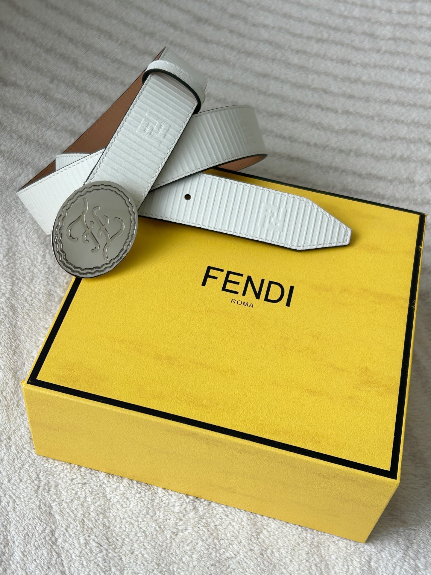  FENDI (芬迪) 男款休闲腰带 宽3.4cm 白色粒面牛皮材质，饰有FF图案和凸纹天然橡胶条纹，银