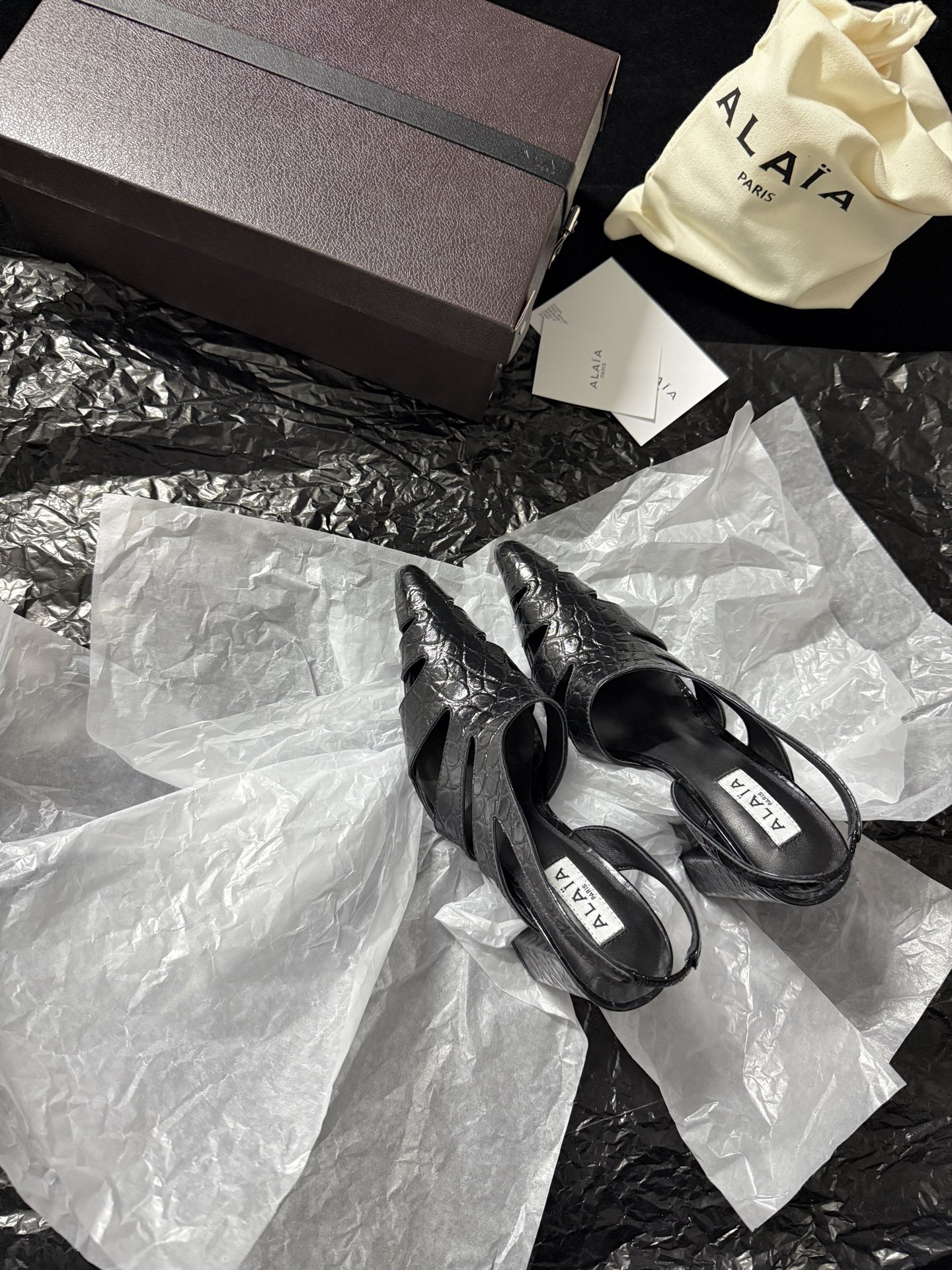 NO:723908,ALAIA / New product ALAA Snake pattern hollow back sandals | The wild flowing poetry of haute couture ALAA reinvents the hollow back sandals with snake-print embossed leather. The geometric hollow cutting wraps around the foot like a sculpture. The pointed toe and back design find the perfect balance between sexy and light. The snake grain texture glows with a cool luster under the light. The hollow design not only eliminates the heavy feeling of leather but also outlines the sexy outline of the foot.  Inject the pioneering gene of haute couture into every detail. Imported cowhide for the upper, imported sheepskin for the lining, and imported genuine leather outsole. Heel height 10cm, 35-39 (set at 40.41.42), high heels and sandals, alaia, sandals, high heels, cowhide, sheepskin, Leather soles.19860909ALAIA /新品 ALAA 蛇纹镂空后空凉鞋｜高定野性的流动诗意 ALAA 以蛇纹压纹皮革重塑后空凉鞋 几何镂空切割如雕塑般缠绕足间 尖头与后空设计在性感与轻盈间找到完美平衡 蛇纹肌理在光线下泛着冷冽光泽 镂空设计既消解了皮革的厚重感 又勾勒出足部的性感轮廓 将高定的先锋基因注入每一处细节 鞋面进口牛皮 内里进口羊皮 进口真皮大底 跟高10cm 35-39（40.41.42定）,高跟鞋凉鞋,alaia,sandals,high heels,cowhide,sheepskin,Leather soles,Women's Shoes