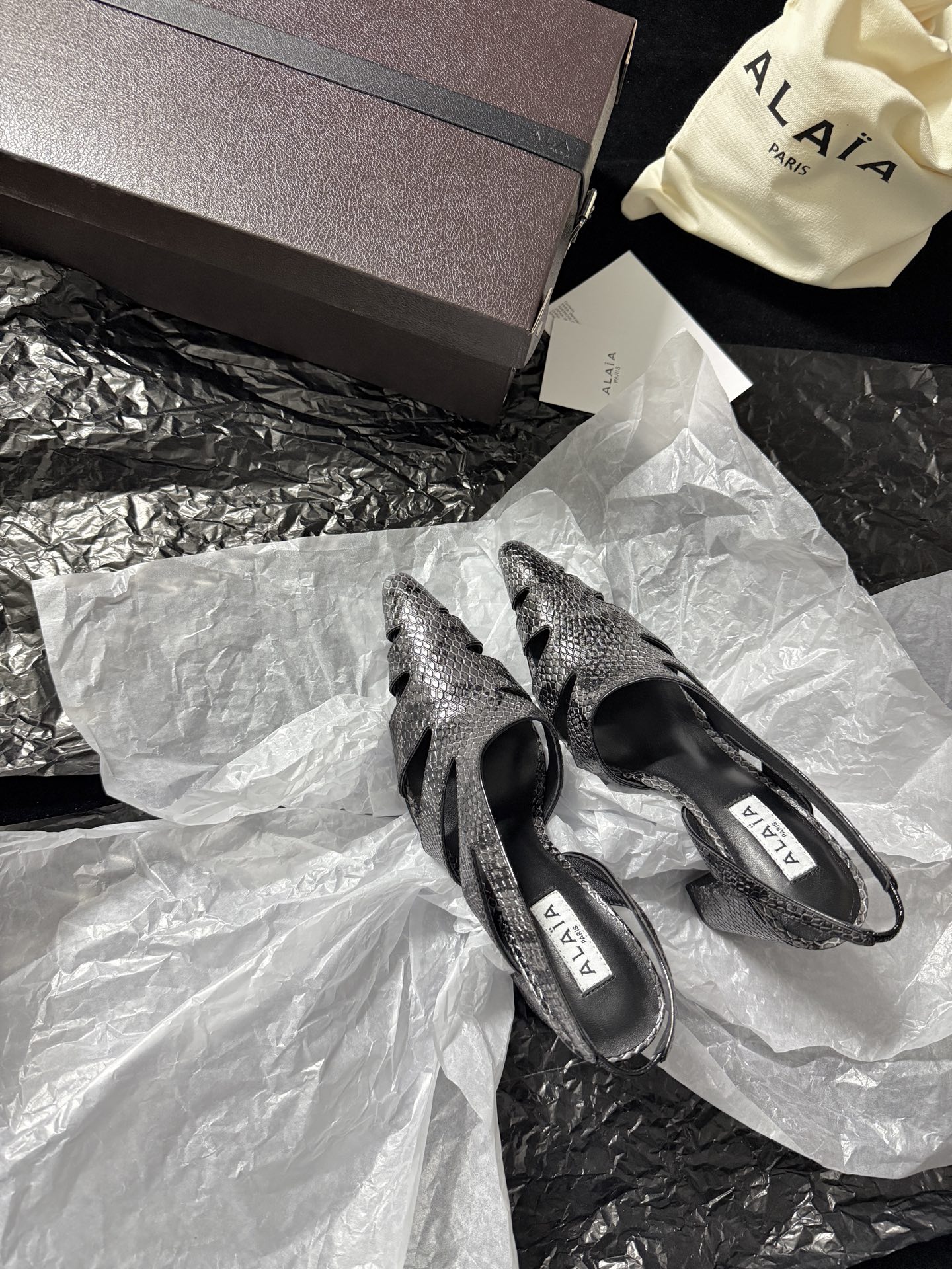 NO:723910,ALAIA / New product ALAA Snake pattern hollow back sandals | The wild flowing poetry of haute couture ALAA reinvents the hollow back sandals with snake-print embossed leather. The geometric hollow cutting wraps around the foot like a sculpture. The pointed toe and back design find the perfect balance between sexy and light. The snake grain texture glows with a cool luster under the light. The hollow design not only eliminates the heavy feeling of leather but also outlines the sexy outline of the foot.  Inject the pioneering gene of haute couture into every detail. Imported cowhide for the upper, imported sheepskin for the lining, and imported genuine leather outsole. Heel height 10cm, 35-39 (set at 40.41.42), high heels and sandals, alaia, sandals, high heels, cowhide, sheepskin, Leather soles.19860909ALAIA /新品 ALAA 蛇纹镂空后空凉鞋｜高定野性的流动诗意 ALAA 以蛇纹压纹皮革重塑后空凉鞋 几何镂空切割如雕塑般缠绕足间 尖头与后空设计在性感与轻盈间找到完美平衡 蛇纹肌理在光线下泛着冷冽光泽 镂空设计既消解了皮革的厚重感 又勾勒出足部的性感轮廓 将高定的先锋基因注入每一处细节 鞋面进口牛皮 内里进口羊皮 进口真皮大底 跟高10cm 35-39（40.41.42定）,高跟鞋凉鞋,alaia,sandals,high heels,cowhide,sheepskin,Leather soles,Women's Shoes