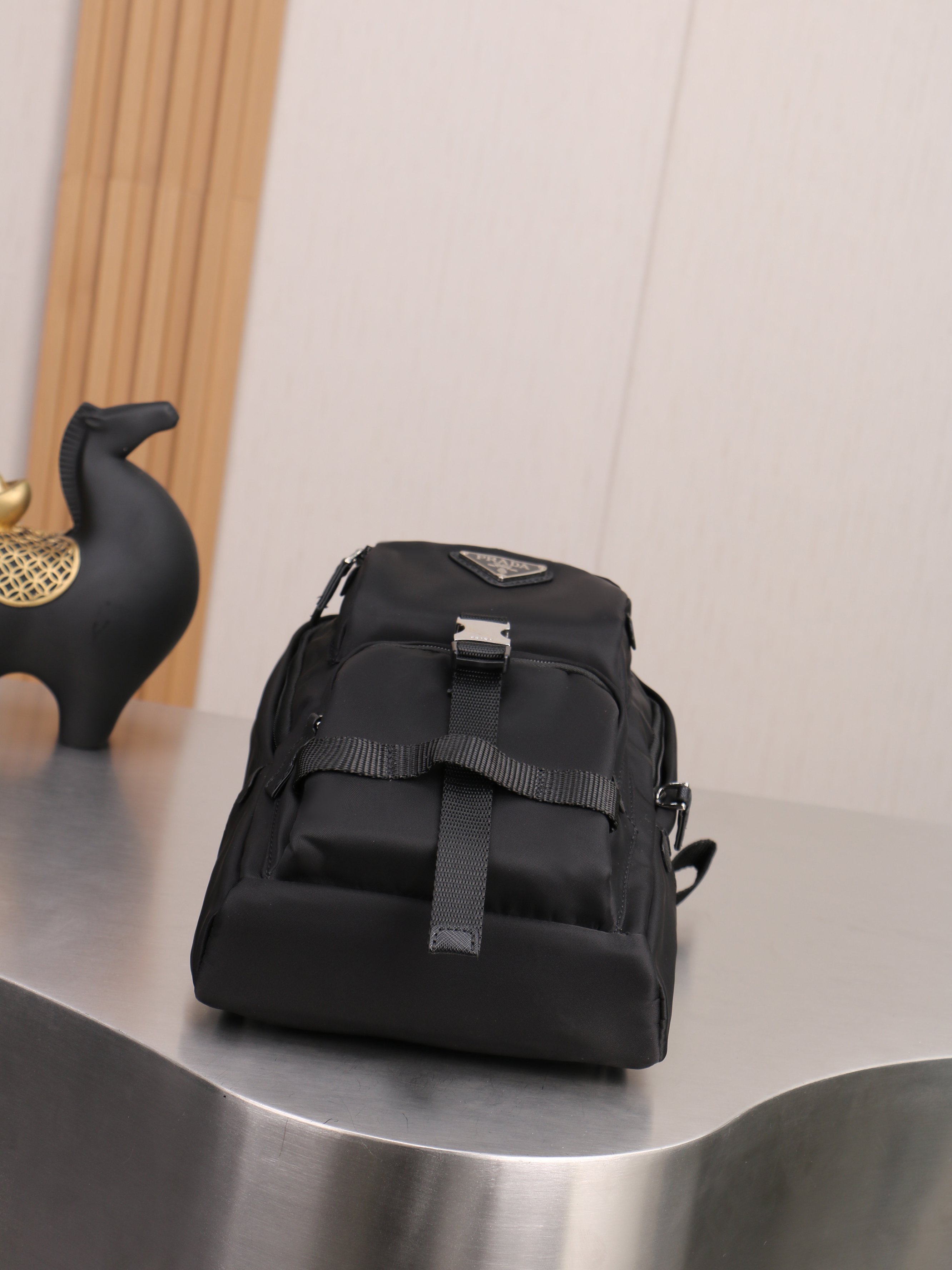 新款。P家专柜新款双肩吊袋🎒背包到货，ECONYL®再生尼龙和Saffiano皮革材质，再生尼龙涂胶织物贴饰+配带扣和磁