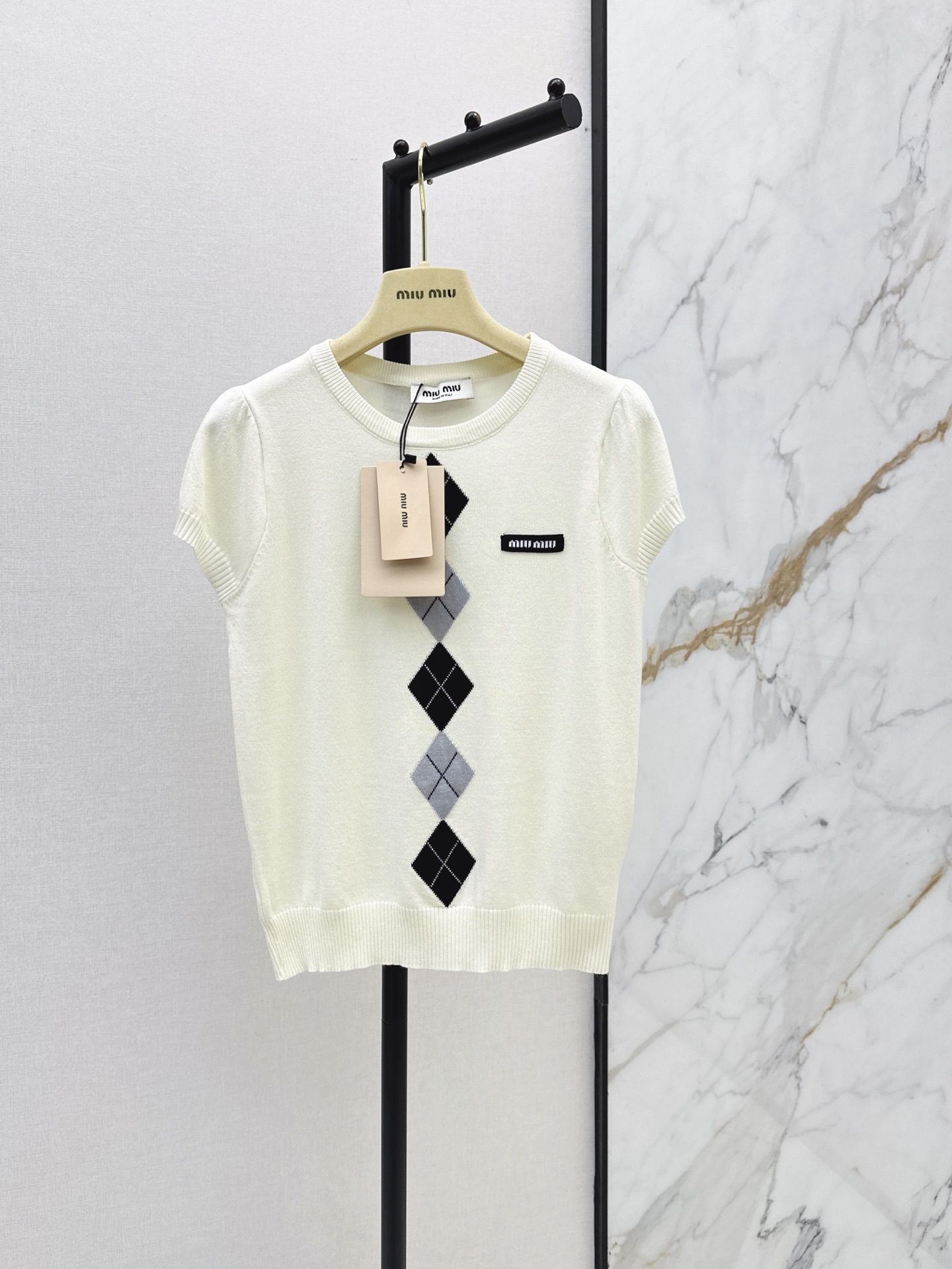 NO:908262,Miu 26Ss——Latest spring and summer rhombus knitted short-sleeved style. Customized wool yarn weaving. Delicate texture, soft and comfortable. Round neck short-sleeved knitted top tailoring. Collar and cuffs spiral hemming. Delicate and soft. Contrasting rhombus pattern on the chest. College style adds youthful atmosphere. Literary and artistic color matching shows British style. Must-have outfit for dating and commuting. Two-color sml,,miumiu,T-shirt,19860909Miu 26Ss————春夏最新款菱格针织短袖 定制羊毛纱线织造 质感细腻 柔软舒适 圆领短袖针织上衣剪裁 领口袖口螺旋纹包边 细致柔软 胸前菱形图案撞色 学院风增加青春气息 文艺感配色尽显英伦风情 约会通勤必备穿搭 两色sml,,miumiu,T-shirt,,Women's clothing