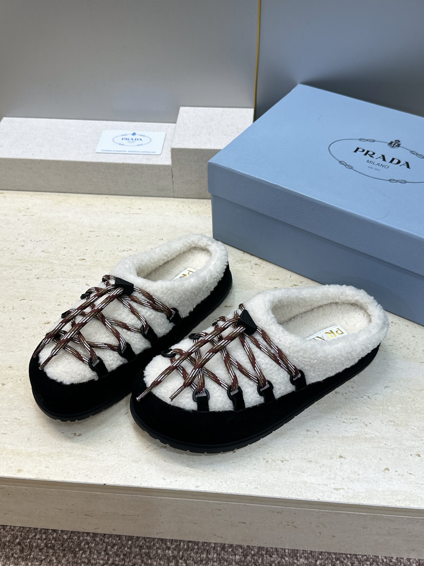 顶级版 Prada 2026秋冬新款羊羔毛系带拼色穆勒女鞋 普拉达字母logo平底圆头防寒保暖拖鞋 材质:鞋面进口羊猄 顶级版 Prada 2026秋冬新款羊羔毛系带拼色穆勒女鞋 普拉达字母logo平底圆头防寒保暖拖鞋 材质:鞋面进口羊猄