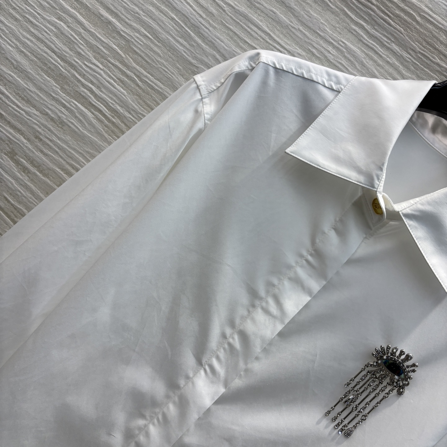Sch家 25春夏新款 翻领水钻雨淋眼睛胸针装饰衬衫 胸针纯手工制作 非常精细   前短后长宽松版型 简