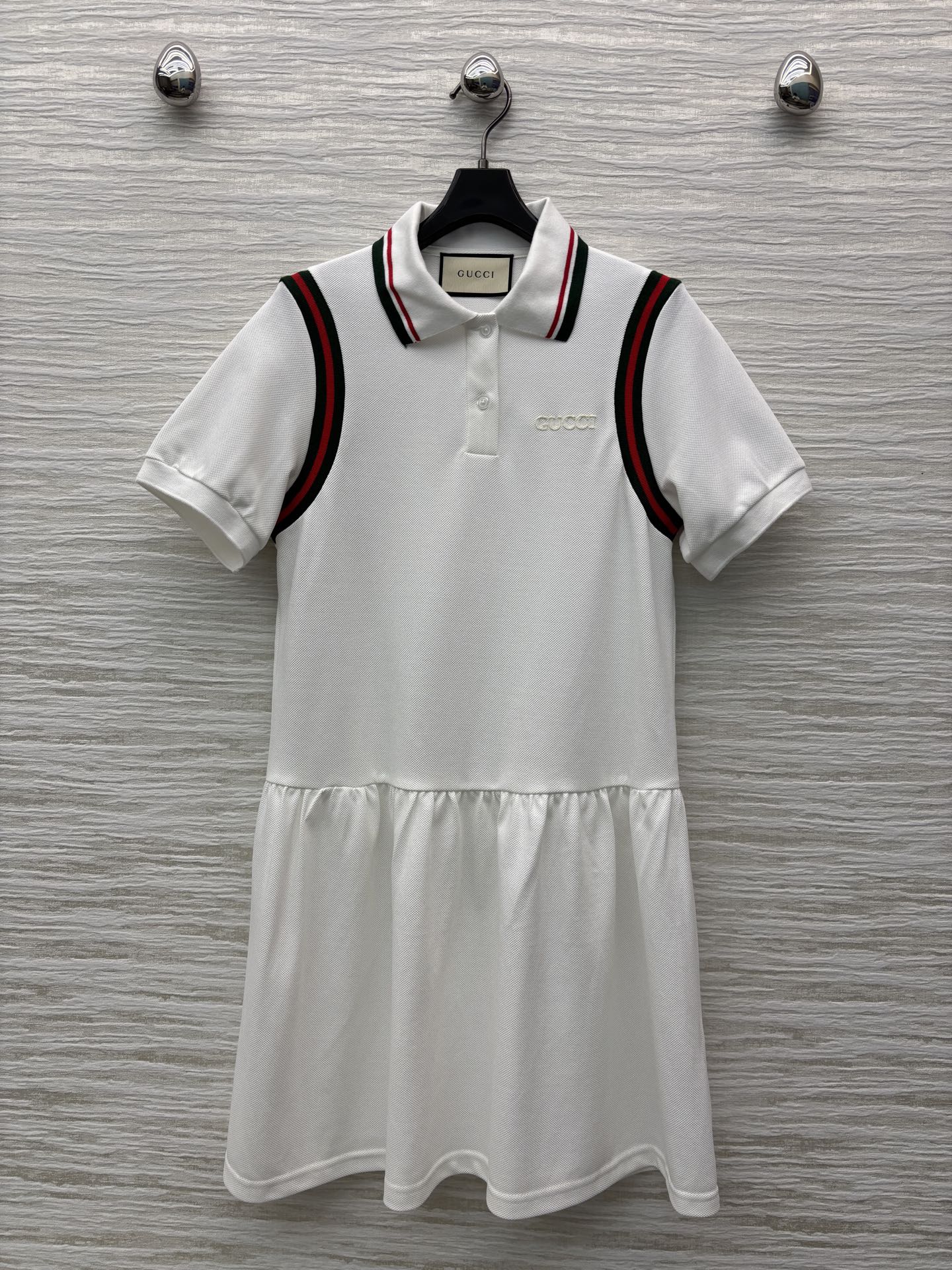 G家25织带拼接polo领短袖连衣裙 简约白色基调尽显干净纯粹 领口撞色织带点缀 拼接百褶裙摆设计 低调