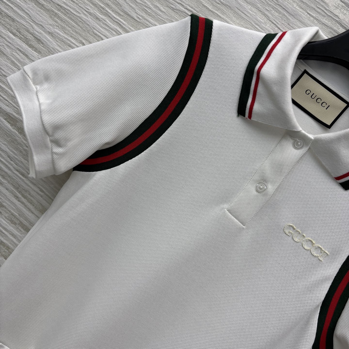 G家25织带拼接polo领短袖连衣裙 简约白色基调尽显干净纯粹 领口撞色织带点缀 拼接百褶裙摆设计 低调