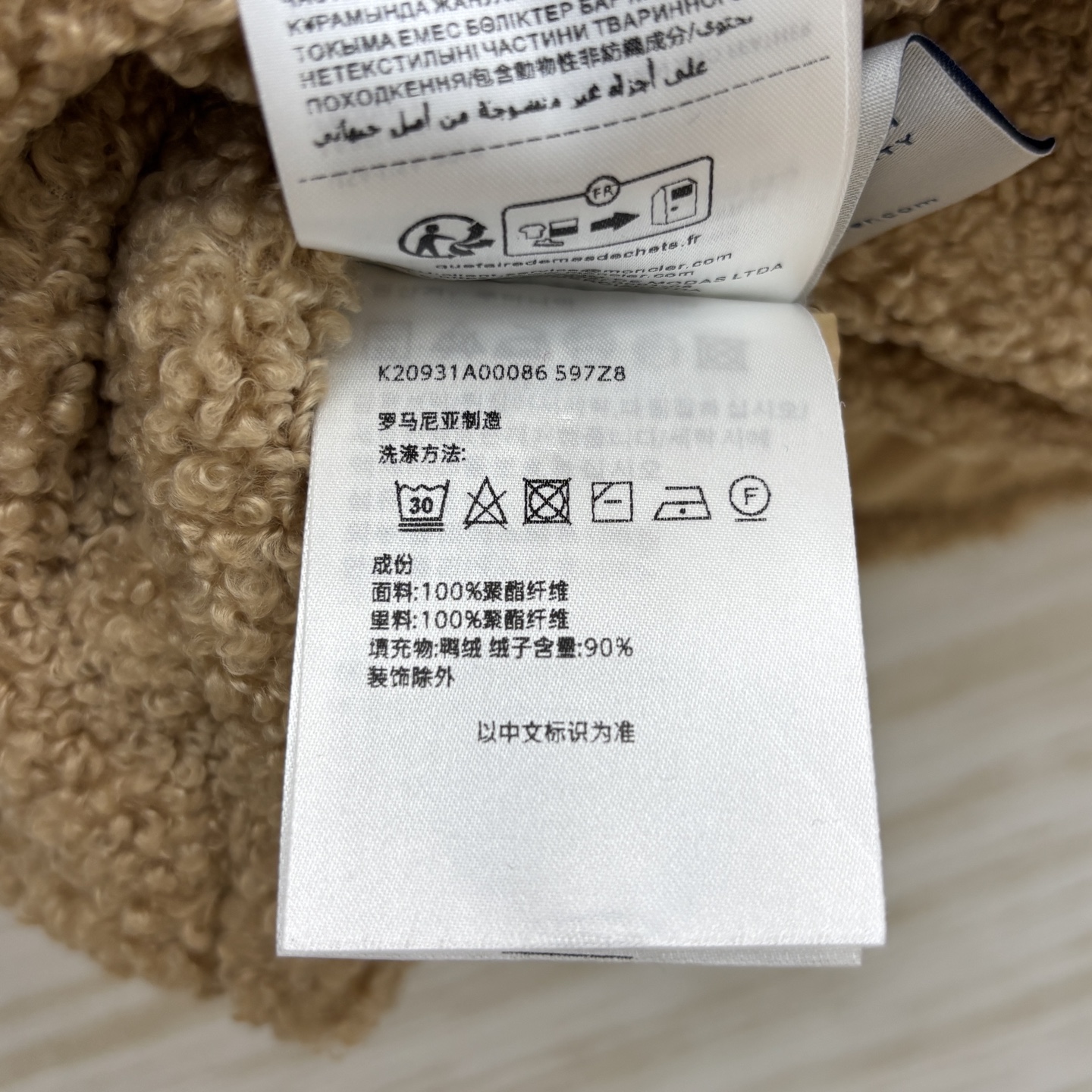 Mo 25秋冬 连帽的驼色羽绒马甲 表面是毛绒质感面料 胸前带有奢侈品标志性的品牌标识 羽绒充填 一色三