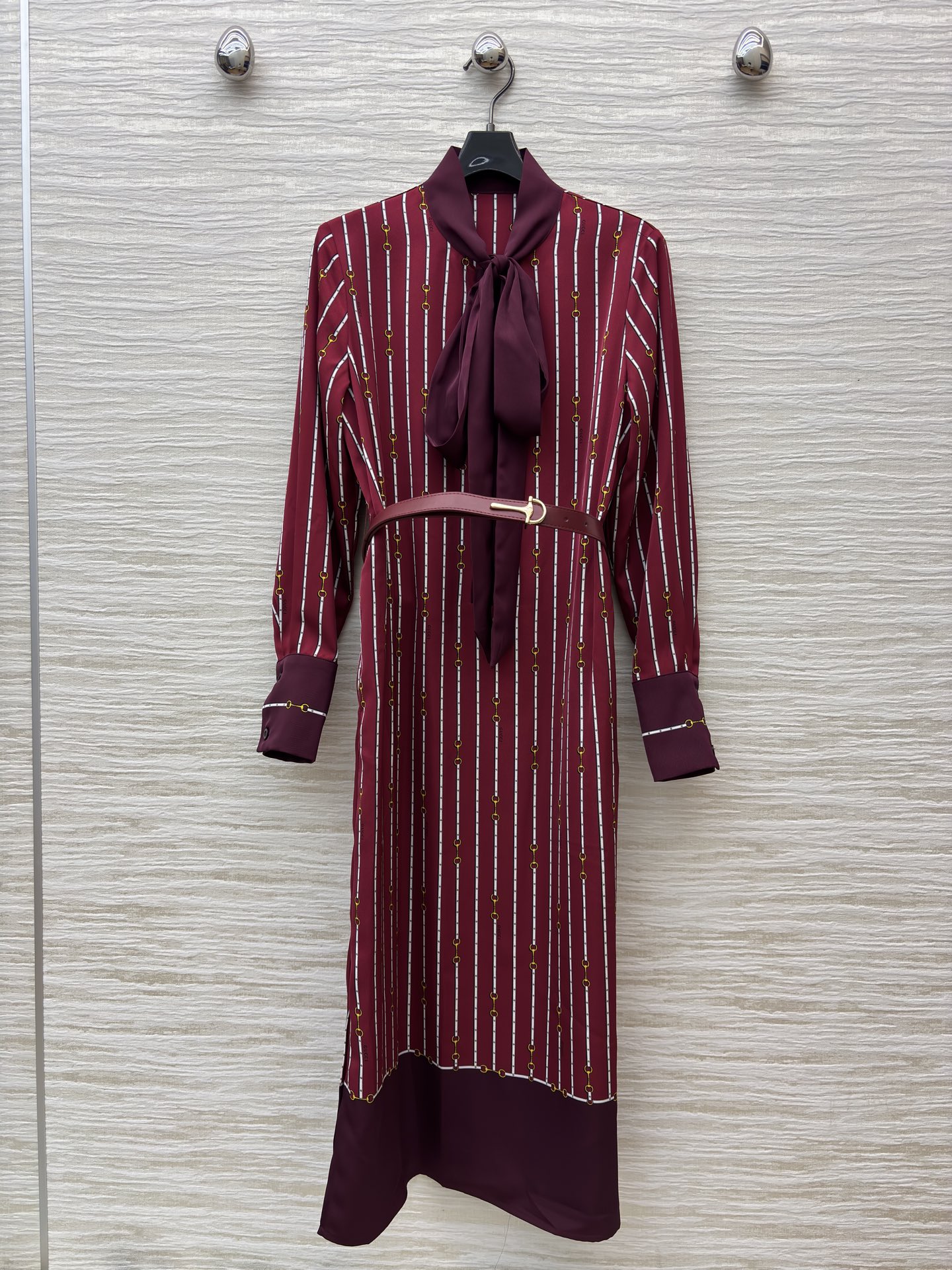 G家25秋季 飘带腰带长袖连衣裙 酒红底色交织着精致条纹与金属链饰 领口飘带添几分柔媚 腰间皮带勾勒优雅