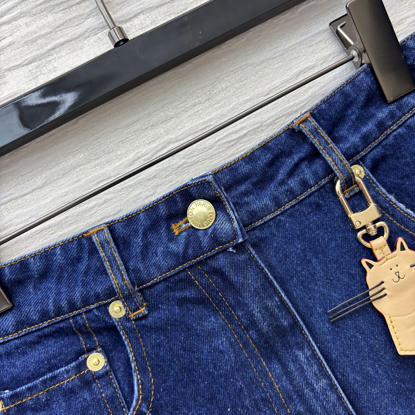 L家25秋冬 猫咪皮牌牛仔系列 经典深蓝色牛仔短裙 版型利落又显活力 搭配精致金属扣与可爱猫咪挂饰 瞬间