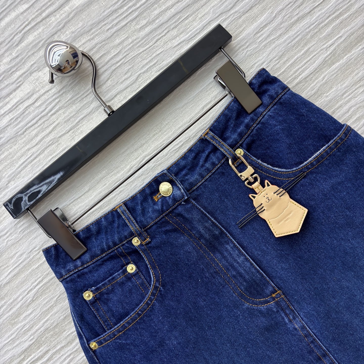 L家25秋冬 猫咪皮牌牛仔系列 经典深蓝色牛仔短裙 版型利落又显活力 搭配精致金属扣与可爱猫咪挂饰 瞬间