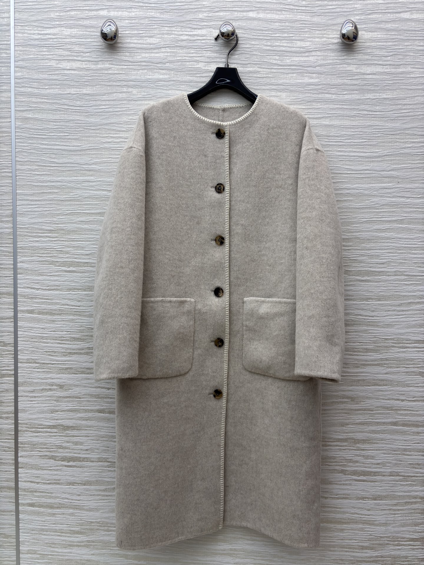 D家25秋浅米色长款羊毛呢外套 秋冬的温柔序曲 圆领设计简约大气 复古纽扣与明线细节尽显质感 大口袋又添