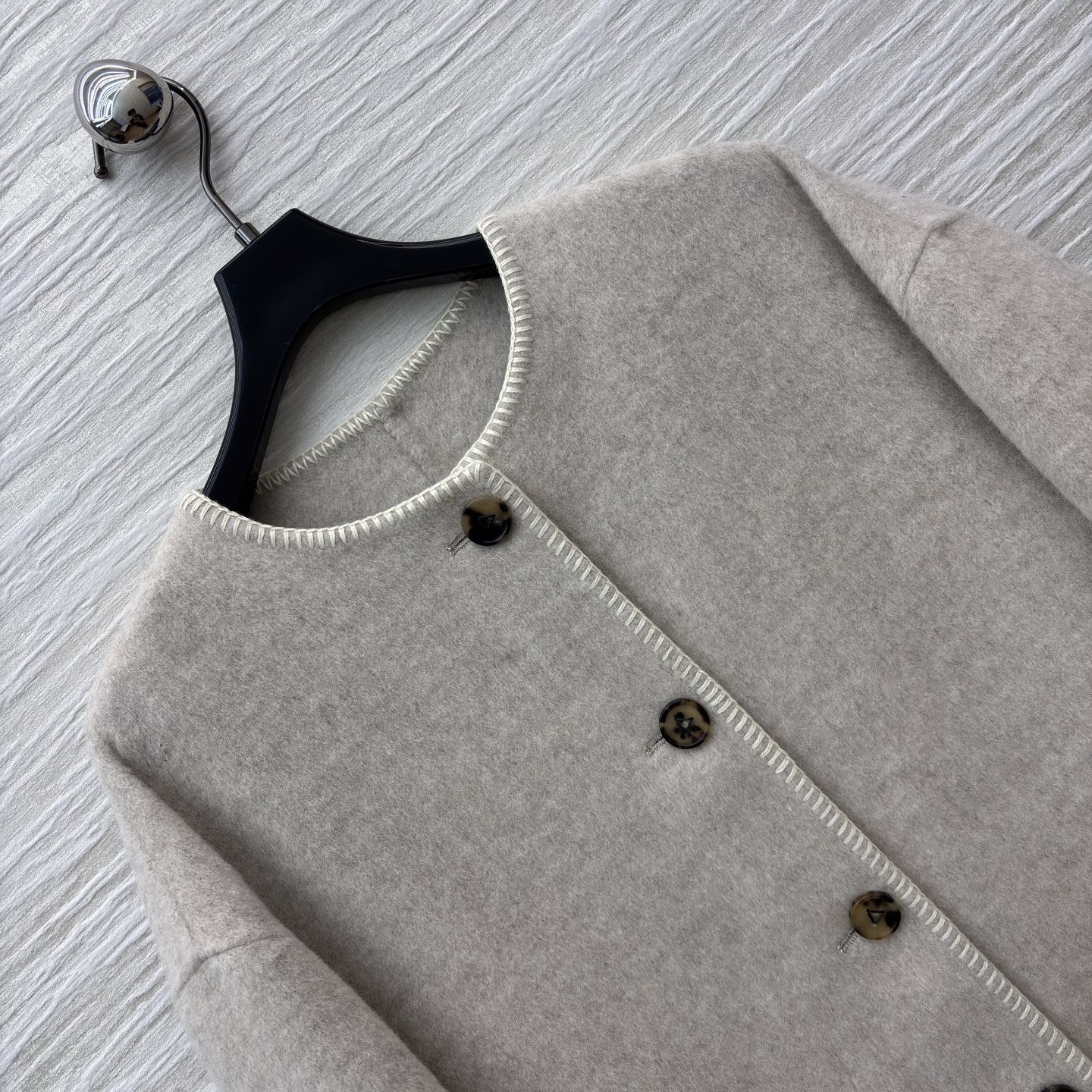 D家25秋浅米色长款羊毛呢外套 秋冬的温柔序曲 圆领设计简约大气 复古纽扣与明线细节尽显质感 大口袋又添