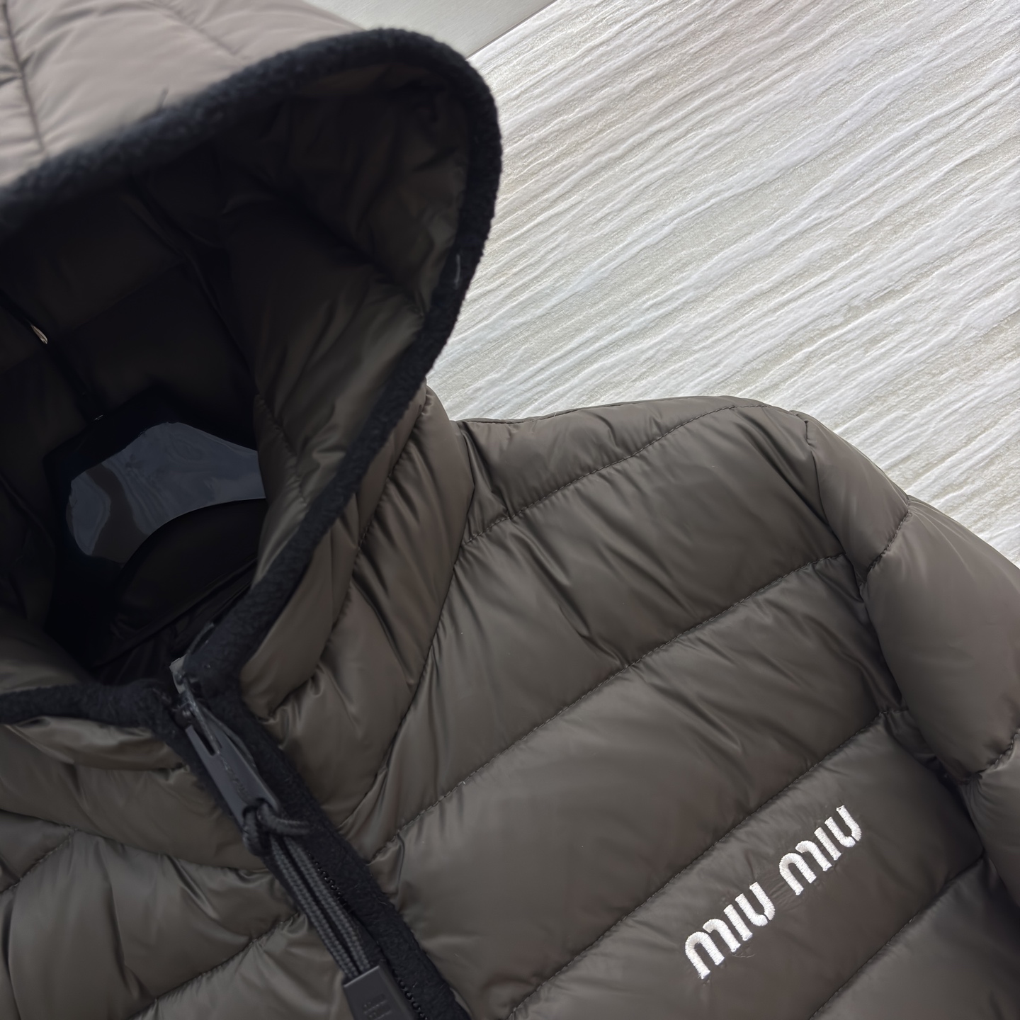 Miu家连帽短款羽绒服 白鹅绒填充 轻奢保暖的时尚选择简约廓形的短款设计 搭配品牌标志性logo 在保暖