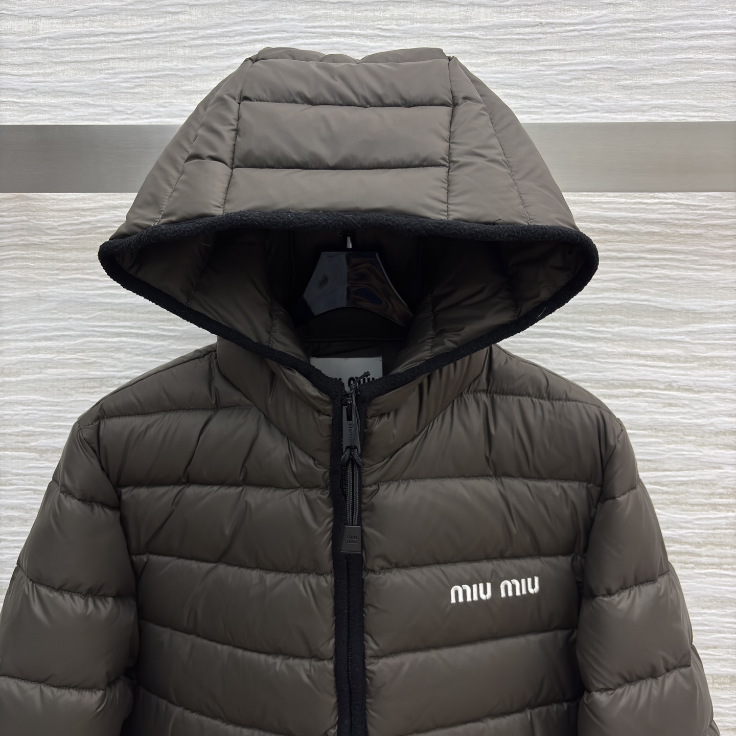 Miu家连帽短款羽绒服 白鹅绒填充 轻奢保暖的时尚选择简约廓形的短款设计 搭配品牌标志性logo 在保暖