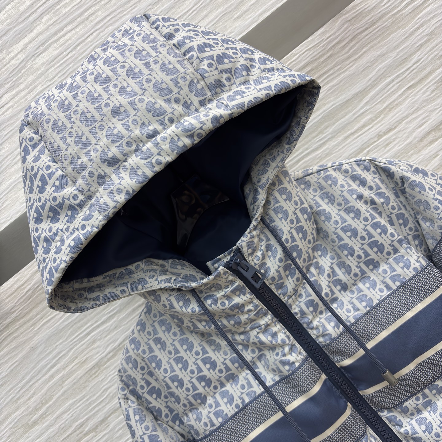 D家 老花连帽羽绒服 冬日高奢御寒典范 满幅Oblique老花贯穿衣身 是品牌基因的高调宣言 藏青条纹拼