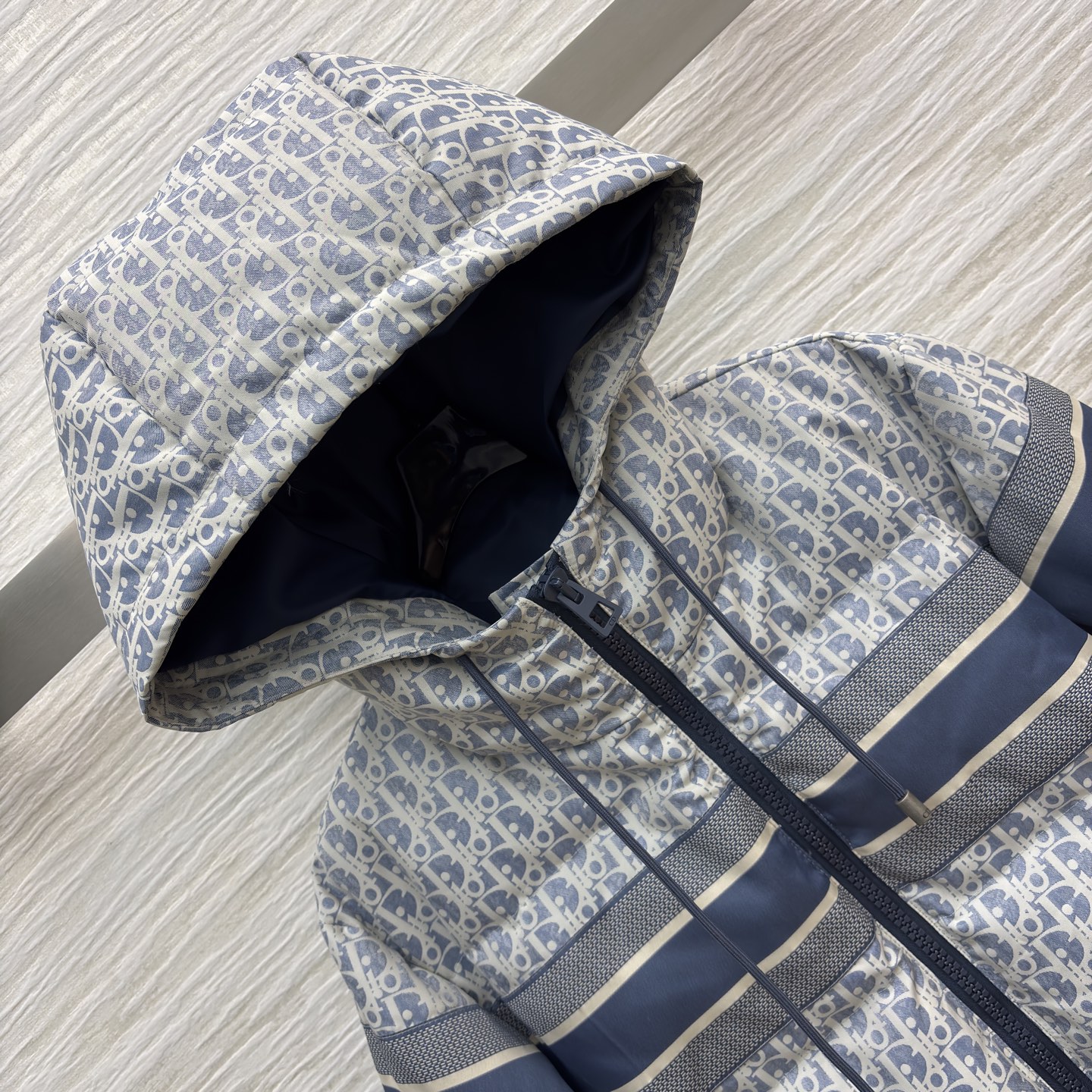 D家 老花连帽羽绒服 冬日高奢御寒典范 满幅Oblique老花贯穿衣身 是品牌基因的高调宣言 藏青条纹拼