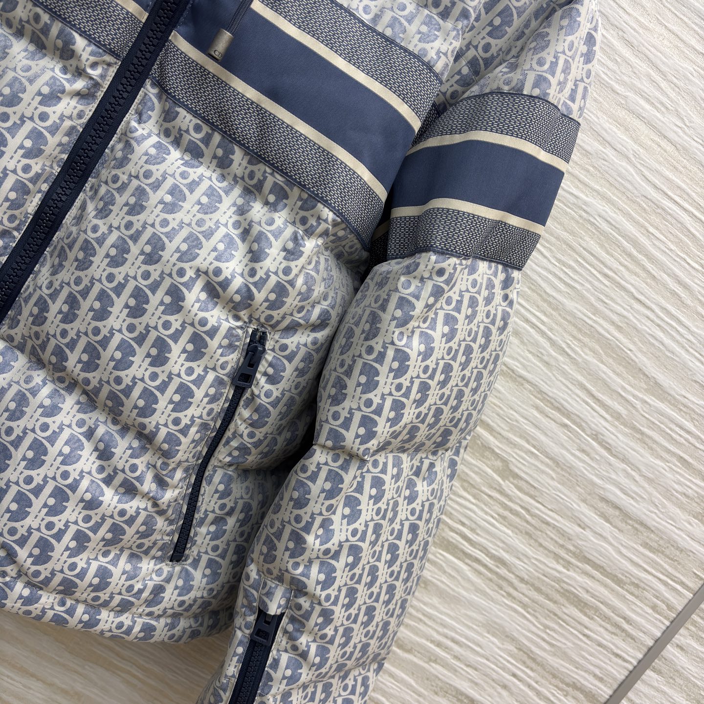 D家 老花连帽羽绒服 冬日高奢御寒典范 满幅Oblique老花贯穿衣身 是品牌基因的高调宣言 藏青条纹拼