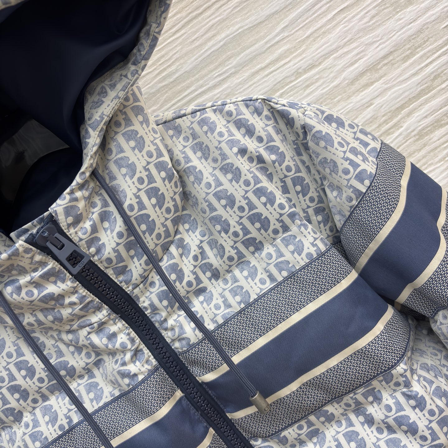 D家 老花连帽羽绒服 冬日高奢御寒典范 满幅Oblique老花贯穿衣身 是品牌基因的高调宣言 藏青条纹拼