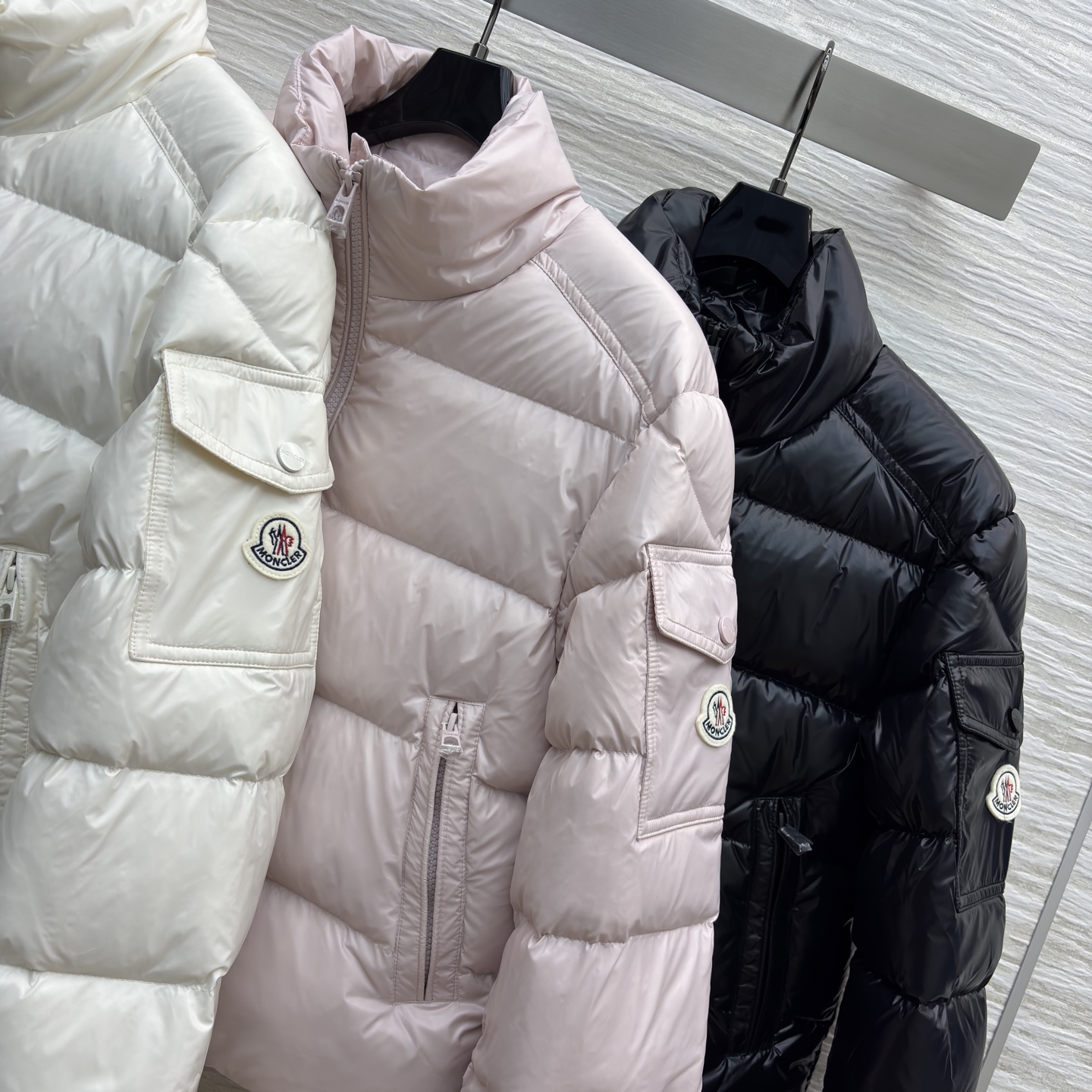 Mo立领短款羽绒服 是冬日时尚的多元选择 亮面材质自带高级感 立领设计保暖又利落 标志性的臂章细节尽显品