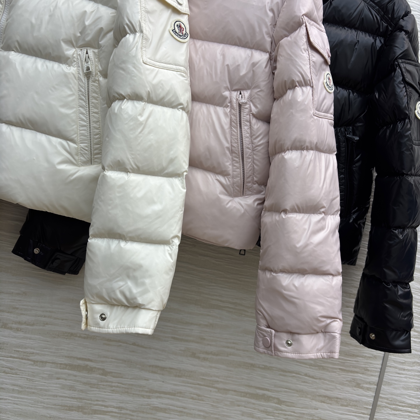 Mo立领短款羽绒服 是冬日时尚的多元选择 亮面材质自带高级感 立领设计保暖又利落 标志性的臂章细节尽显品