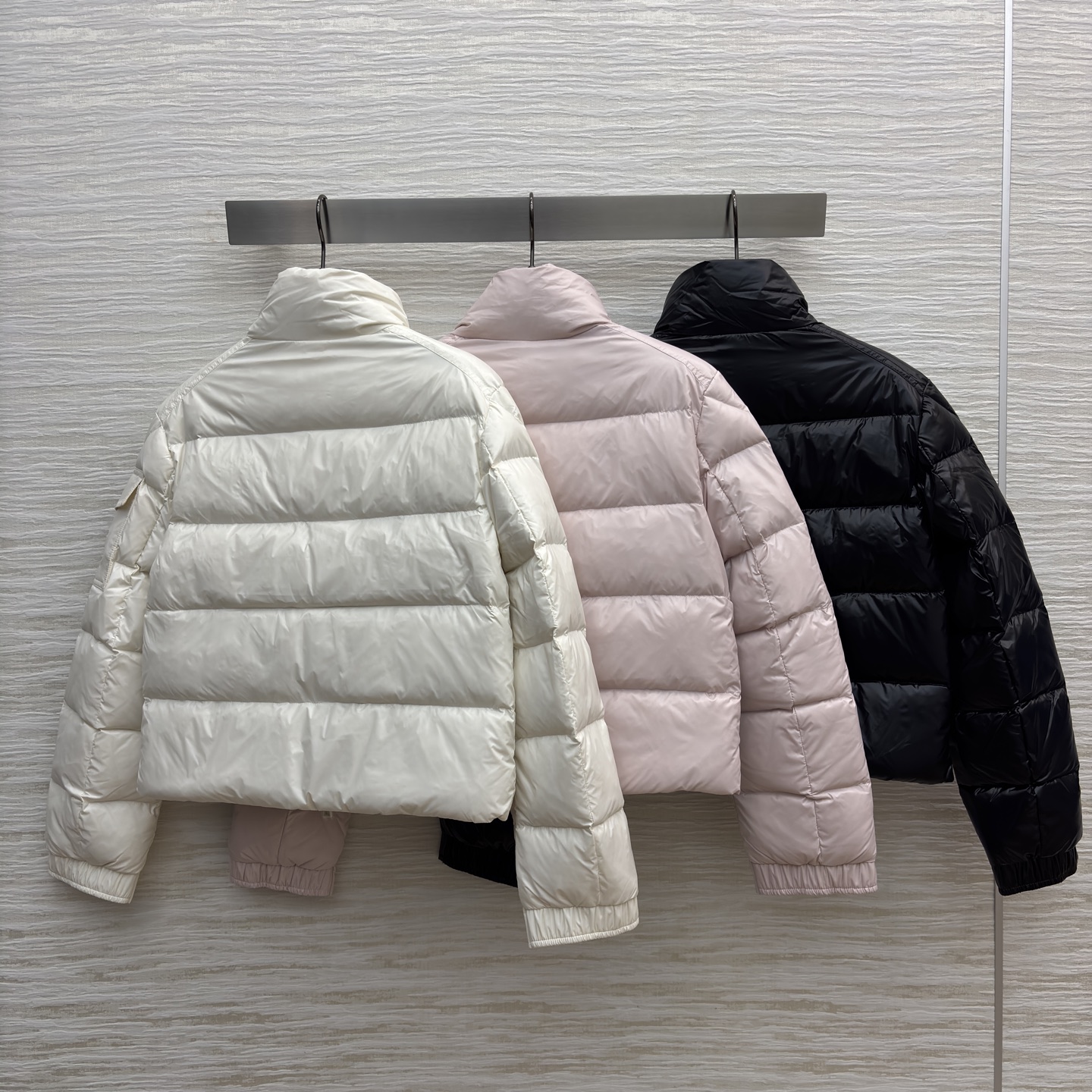 Mo立领短款羽绒服 是冬日时尚的多元选择 亮面材质自带高级感 立领设计保暖又利落 标志性的臂章细节尽显品