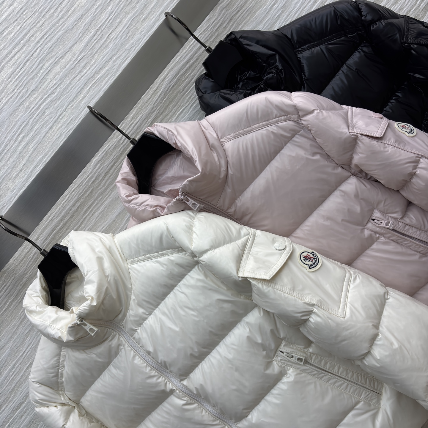 Mo立领短款羽绒服 是冬日时尚的多元选择 亮面材质自带高级感 立领设计保暖又利落 标志性的臂章细节尽显品