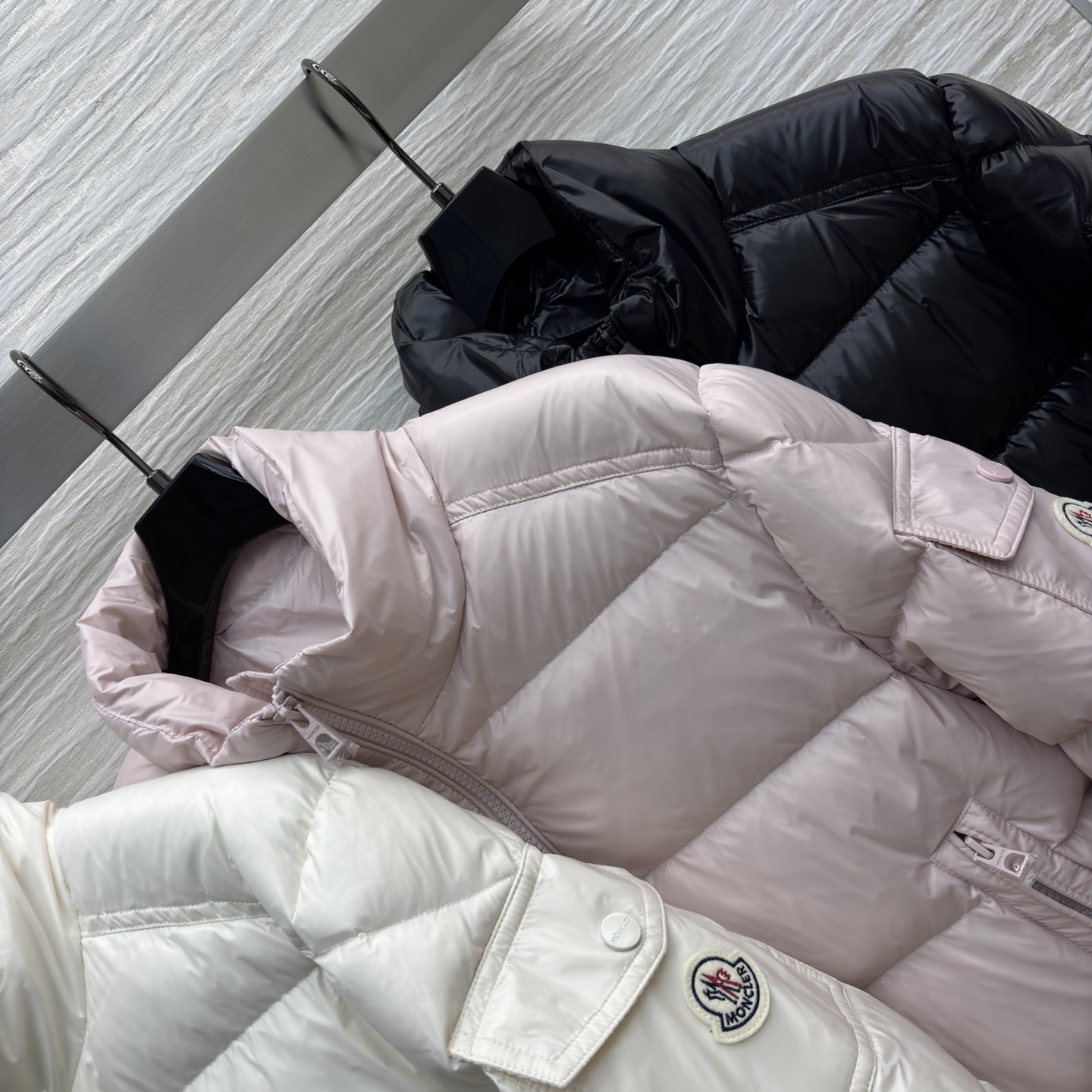 Mo立领短款羽绒服 是冬日时尚的多元选择 亮面材质自带高级感 立领设计保暖又利落 标志性的臂章细节尽显品