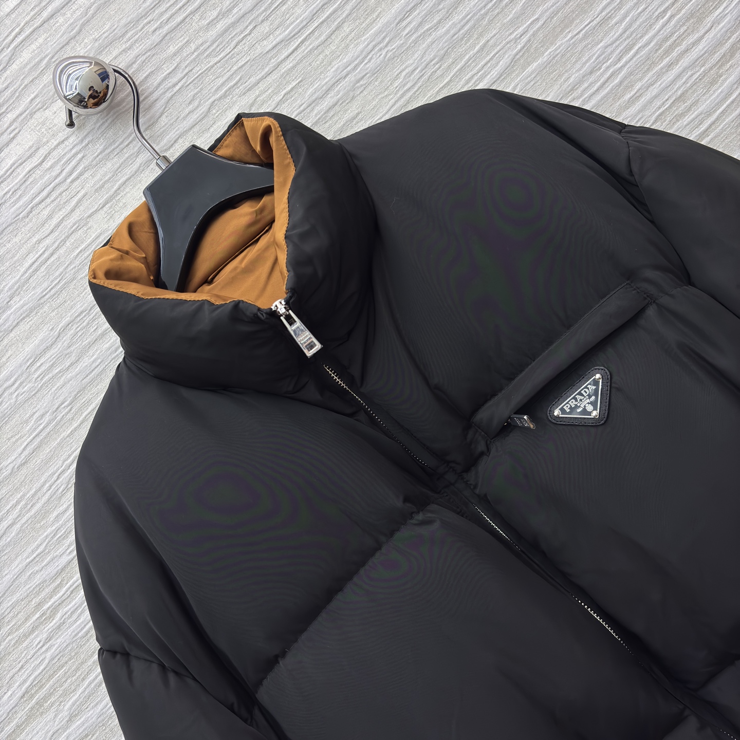 PD 25秋冬 立领黑色羽绒服 是冬日里的时尚“暖盾” 立领设计抵御寒风 腰带收腰勾勒身形 标志性三角标