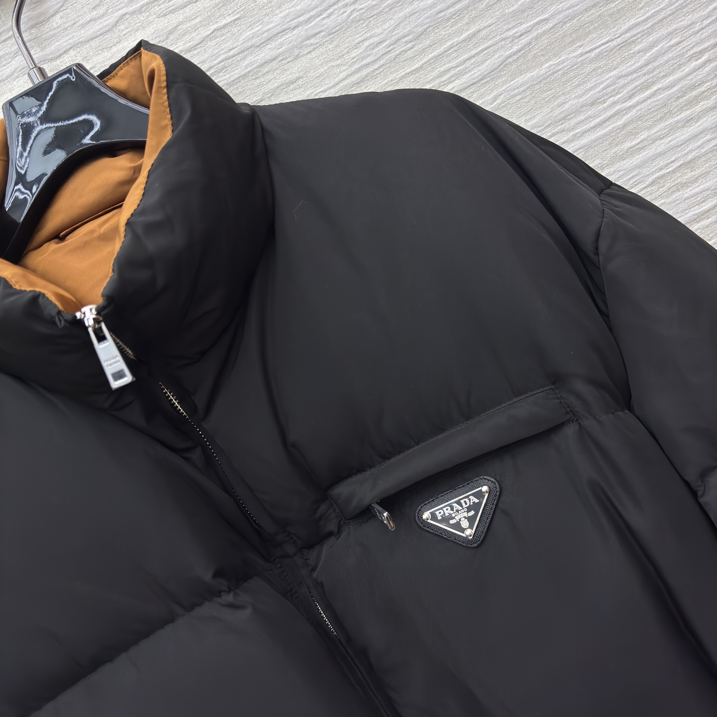 PD 25秋冬 立领黑色羽绒服 是冬日里的时尚“暖盾” 立领设计抵御寒风 腰带收腰勾勒身形 标志性三角标