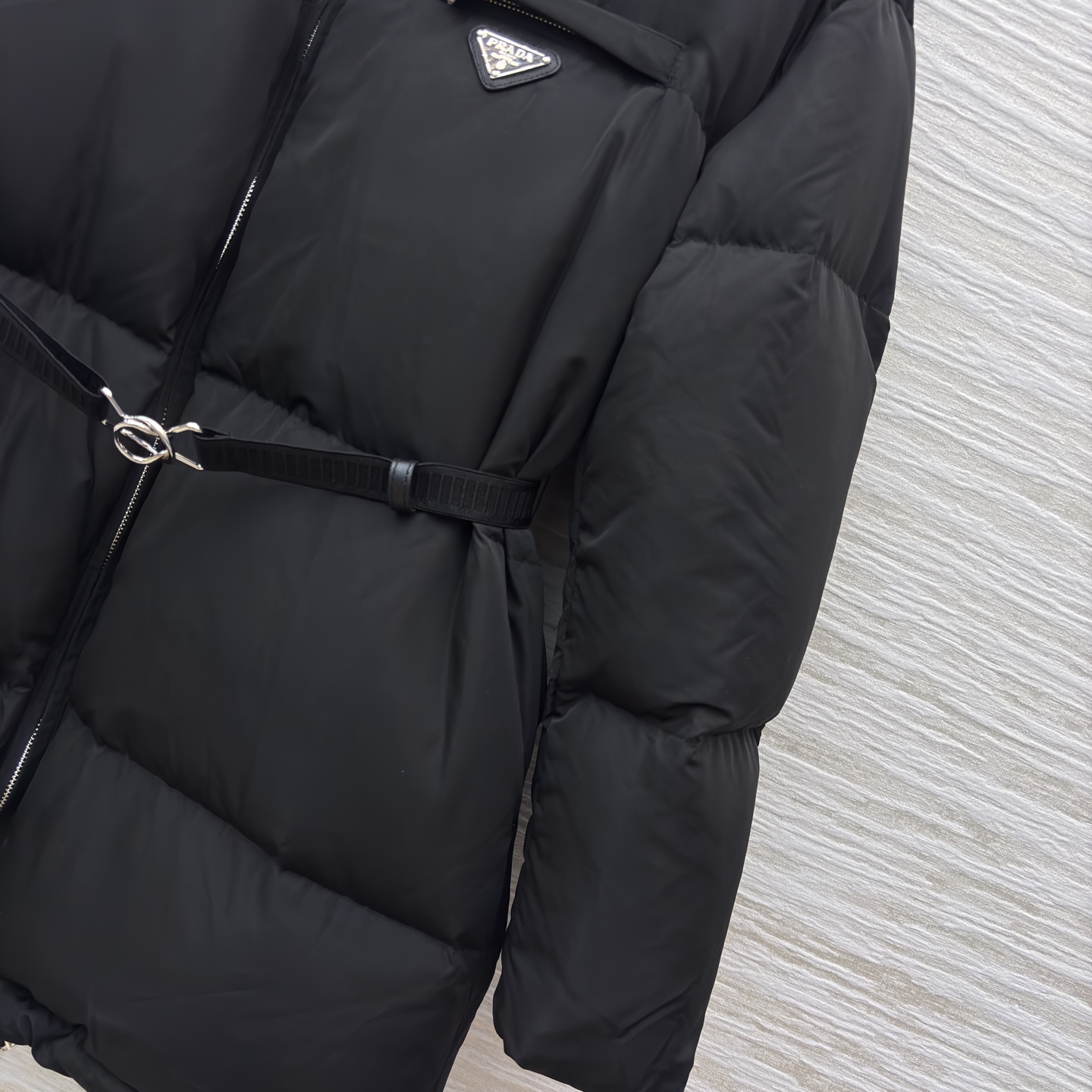 PD 25秋冬 立领黑色羽绒服 是冬日里的时尚“暖盾” 立领设计抵御寒风 腰带收腰勾勒身形 标志性三角标