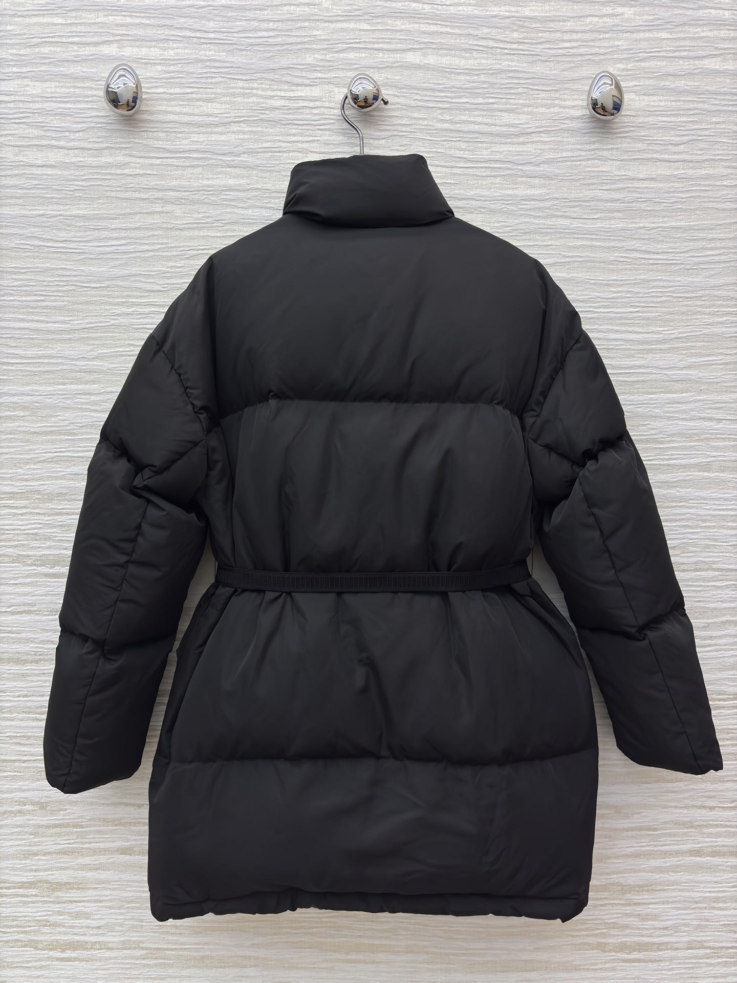 PD 25秋冬 立领黑色羽绒服 是冬日里的时尚“暖盾” 立领设计抵御寒风 腰带收腰勾勒身形 标志性三角标