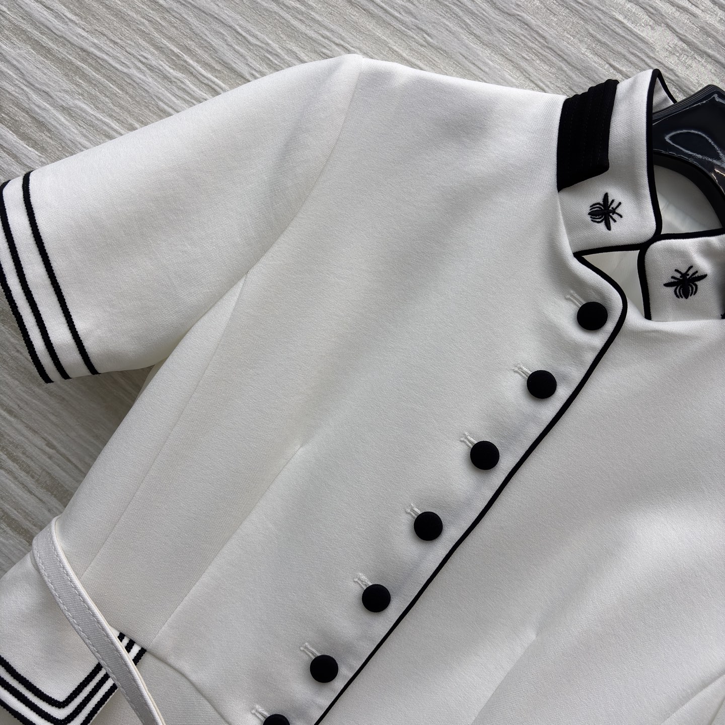 D家25 一袭白裙 黑边与黑扣点缀出复古风情 立领蜜蜂刺绣精致细节 腰间的腰带勾勒 让优雅与干练完美融合