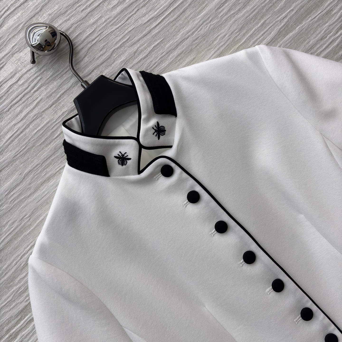 D家25 一袭白裙 黑边与黑扣点缀出复古风情 立领蜜蜂刺绣精致细节 腰间的腰带勾勒 让优雅与干练完美融合