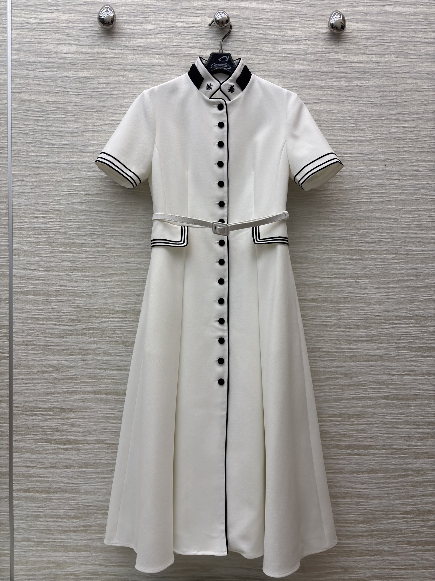 D家25 一袭白裙 黑边与黑扣点缀出复古风情 立领蜜蜂刺绣精致细节 腰间的腰带勾勒 让优雅与干练完美融合