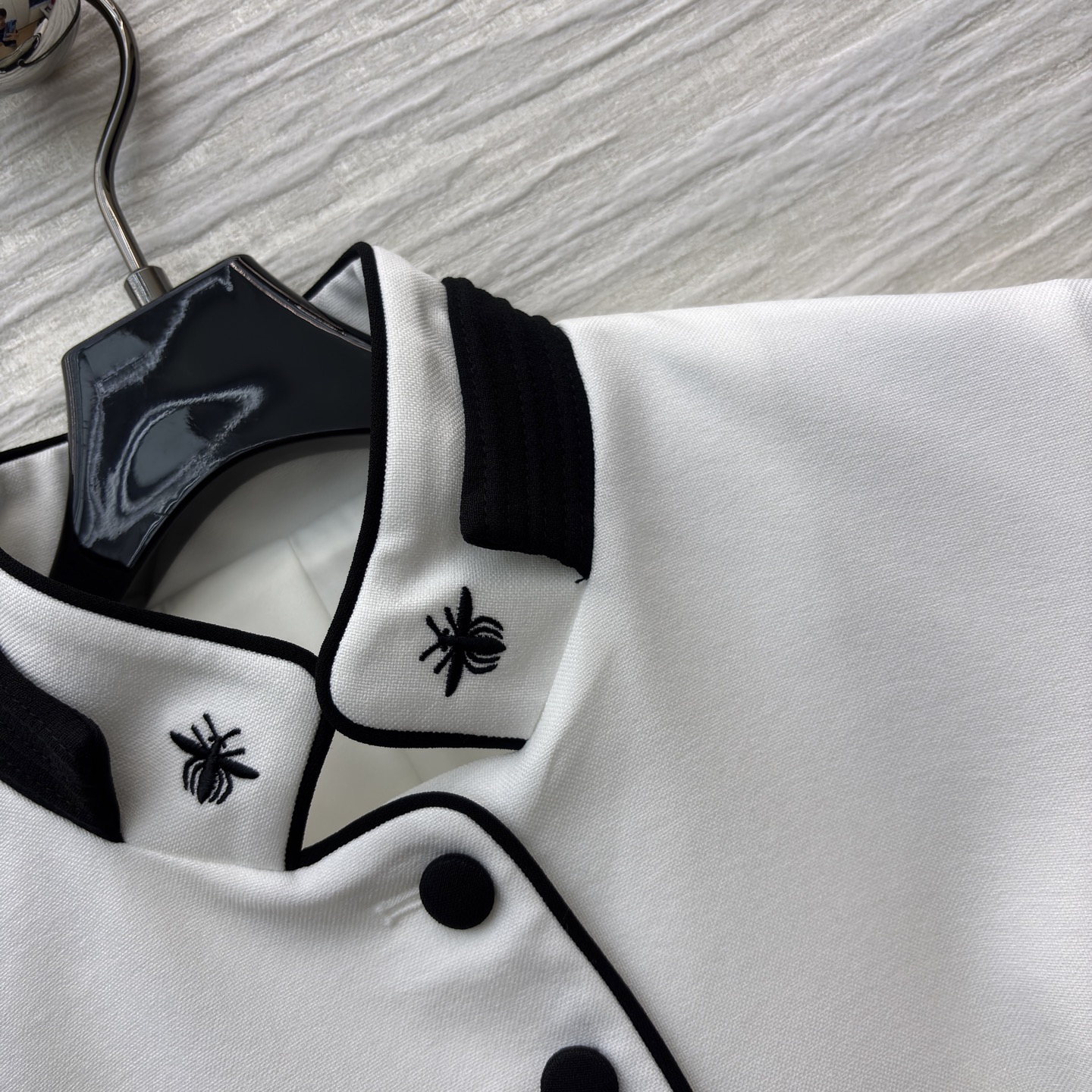 D家25 一袭白裙 黑边与黑扣点缀出复古风情 立领蜜蜂刺绣精致细节 腰间的腰带勾勒 让优雅与干练完美融合