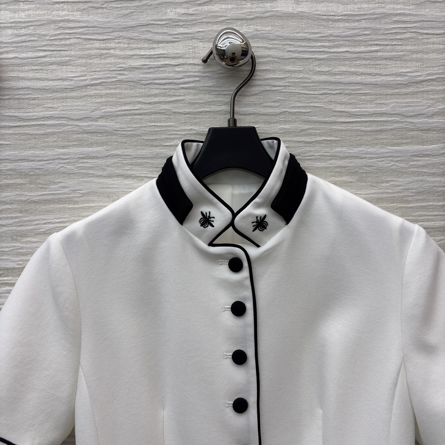 D家25 一袭白裙 黑边与黑扣点缀出复古风情 立领蜜蜂刺绣精致细节 腰间的腰带勾勒 让优雅与干练完美融合