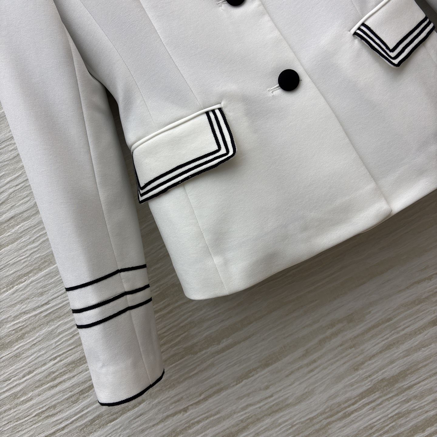 D家 撞领西装外套 极简白与经典黑的碰撞 这件西装上演绎得恰到好处 黑领 黑扣 袖口与口袋的黑边装饰 每