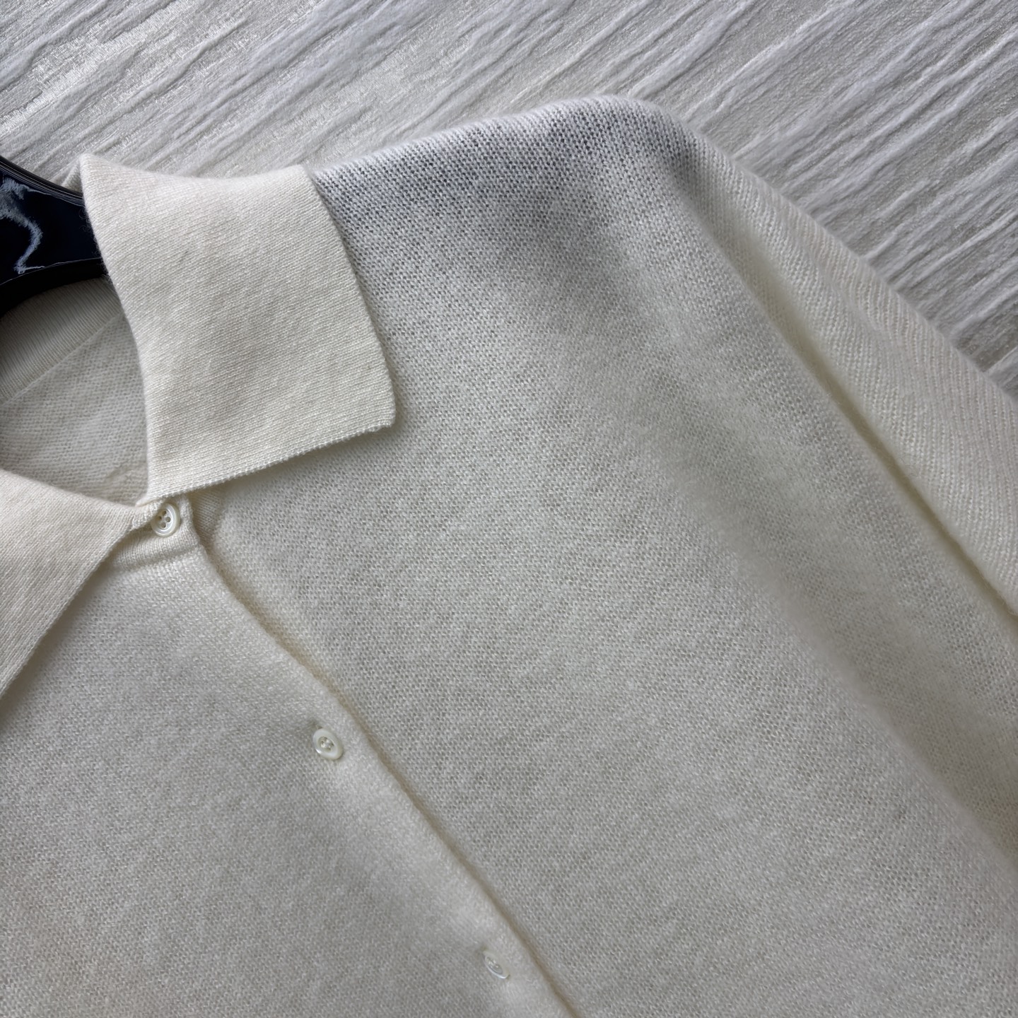 ES米白色羊绒开衫 是温柔与精致的邂逅 经典翻领单排扣设计简约大气 下摆处的镂空蕾丝花纹如繁花绽放 细腻