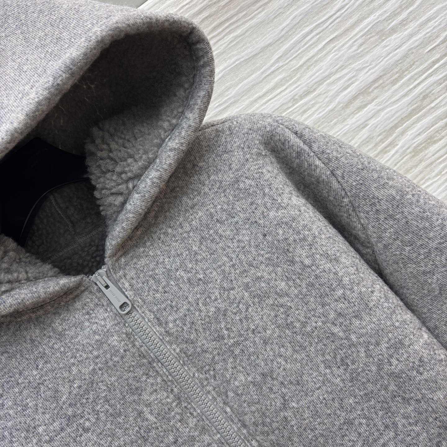 Miu灰调连帽外套 秋冬的松弛暖意 毛呢质感裹着内里绒绒暖意 连帽设计藏起随性松弛 简约版型适配日常多场