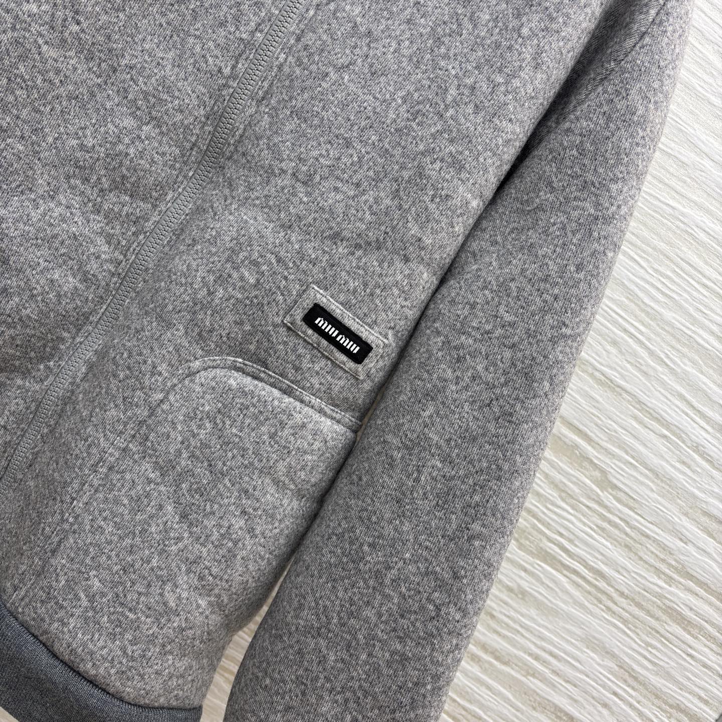 Miu灰调连帽外套 秋冬的松弛暖意 毛呢质感裹着内里绒绒暖意 连帽设计藏起随性松弛 简约版型适配日常多场