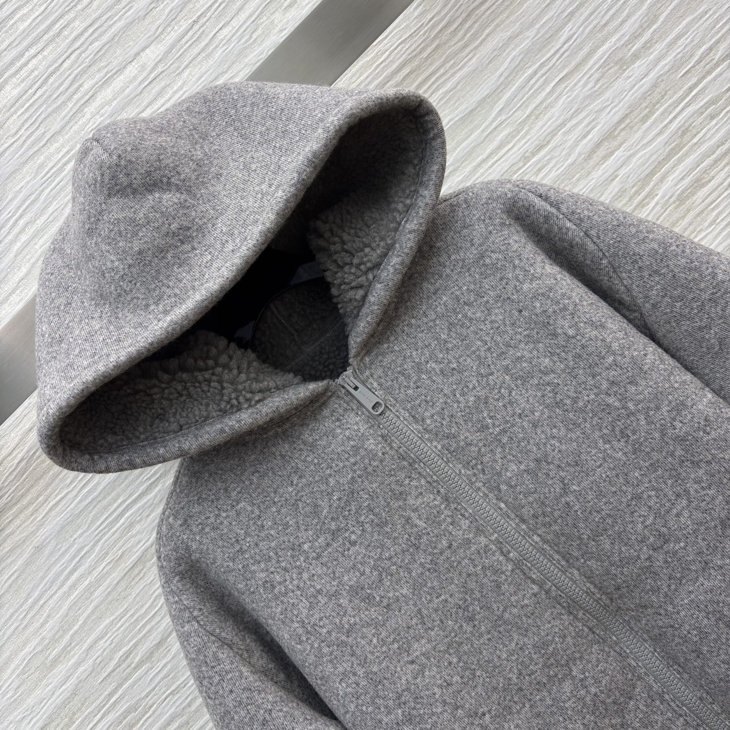 Miu灰调连帽外套 秋冬的松弛暖意 毛呢质感裹着内里绒绒暖意 连帽设计藏起随性松弛 简约版型适配日常多场