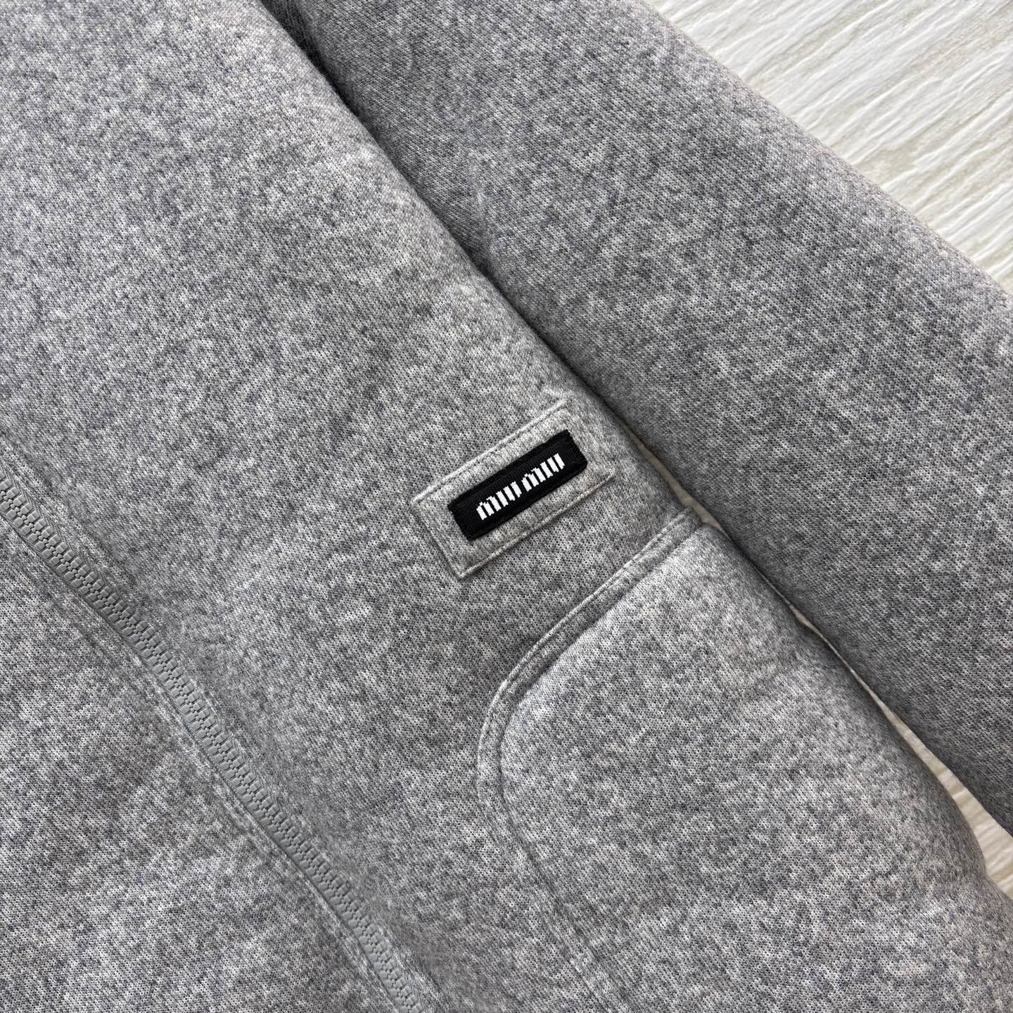 Miu灰调连帽外套 秋冬的松弛暖意 毛呢质感裹着内里绒绒暖意 连帽设计藏起随性松弛 简约版型适配日常多场