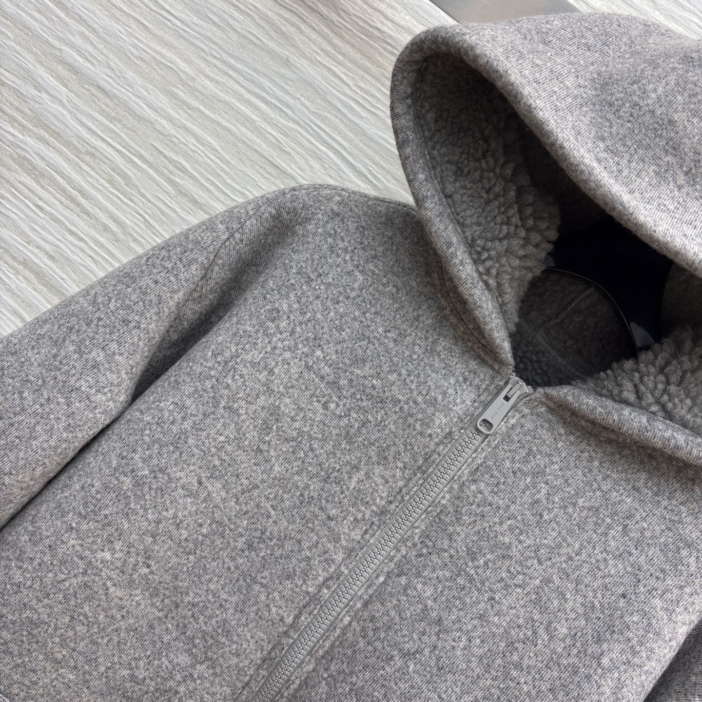 Miu灰调连帽外套 秋冬的松弛暖意 毛呢质感裹着内里绒绒暖意 连帽设计藏起随性松弛 简约版型适配日常多场