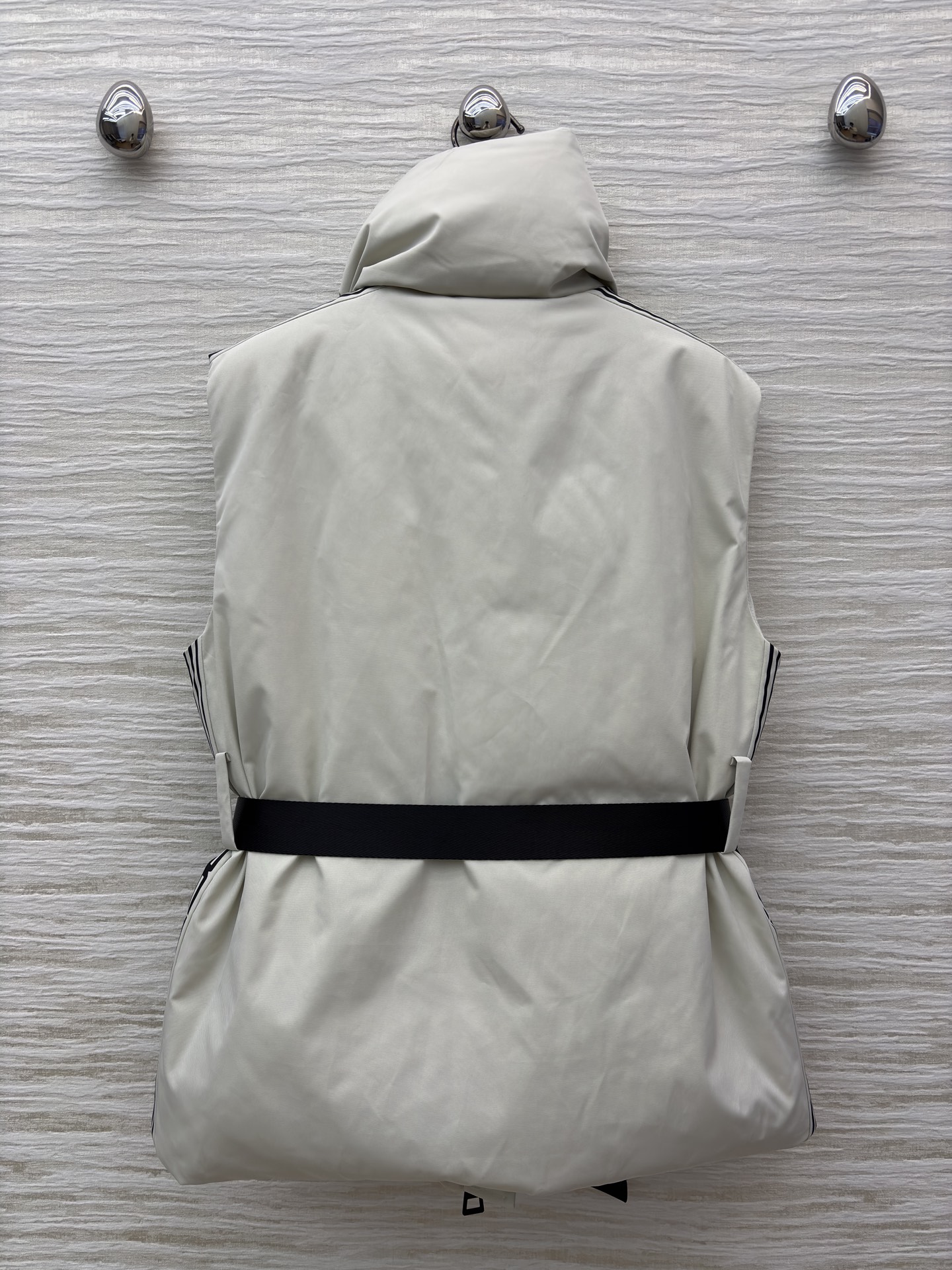 D家 立领腰带羽绒马甲 是秋冬造型的“显瘦神器” 自带极简质感 黑色拉链与腰带收出利落腰线 侧边条纹细节