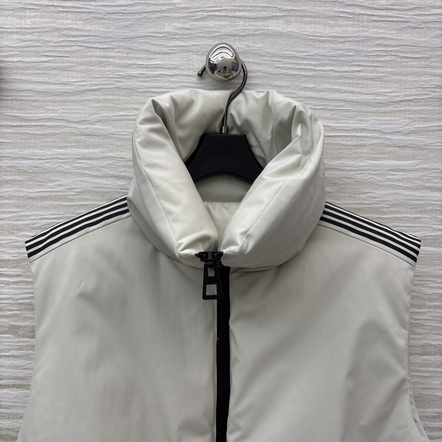 D家 立领腰带羽绒马甲 是秋冬造型的“显瘦神器” 自带极简质感 黑色拉链与腰带收出利落腰线 侧边条纹细节