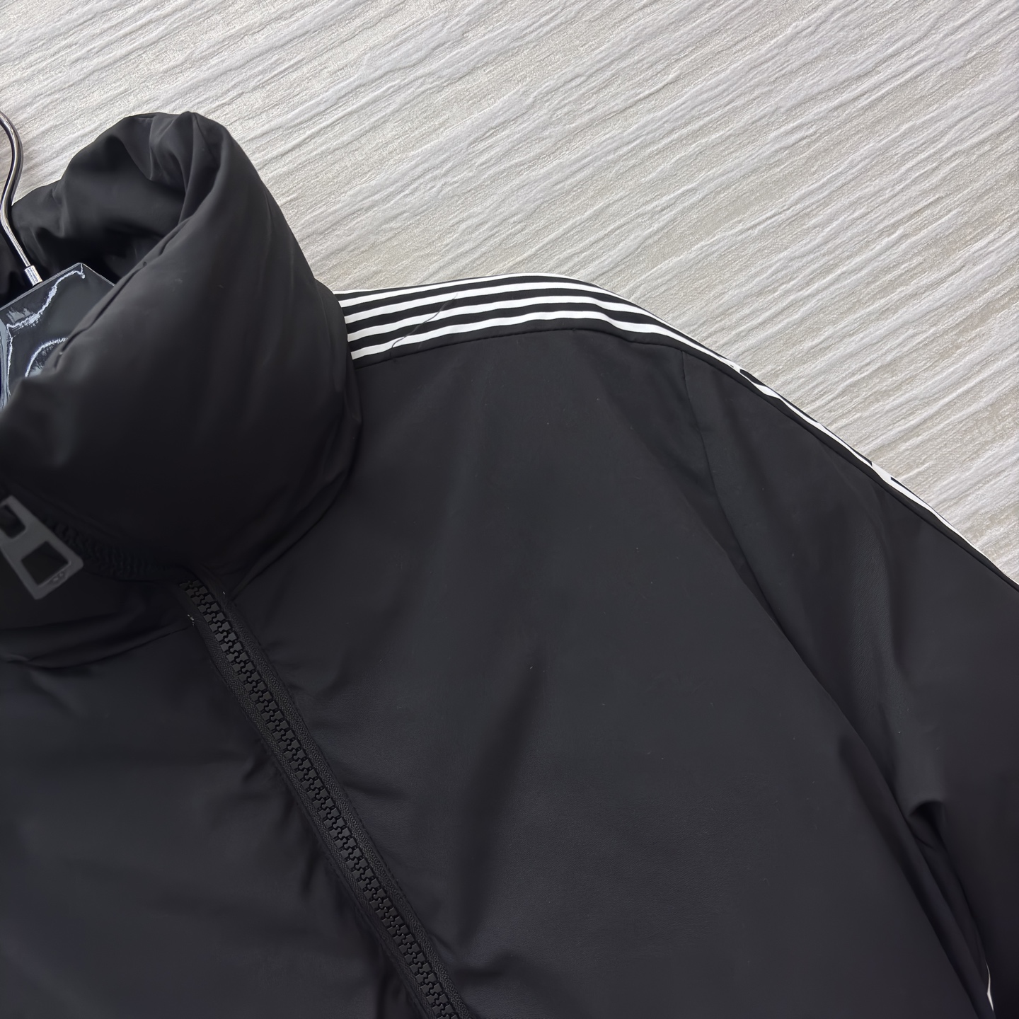 D家 立领收腰羽绒服 是冬日酷感穿搭的首选 立领收腰腰带勾勒利落身形 侧边条纹细节打破纯黑沉闷 蓬松白鸭