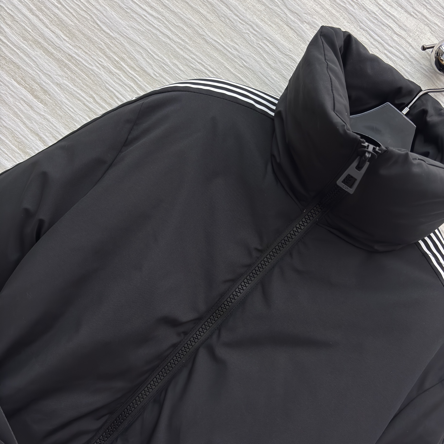 D家 立领收腰羽绒服 是冬日酷感穿搭的首选 立领收腰腰带勾勒利落身形 侧边条纹细节打破纯黑沉闷 蓬松白鸭