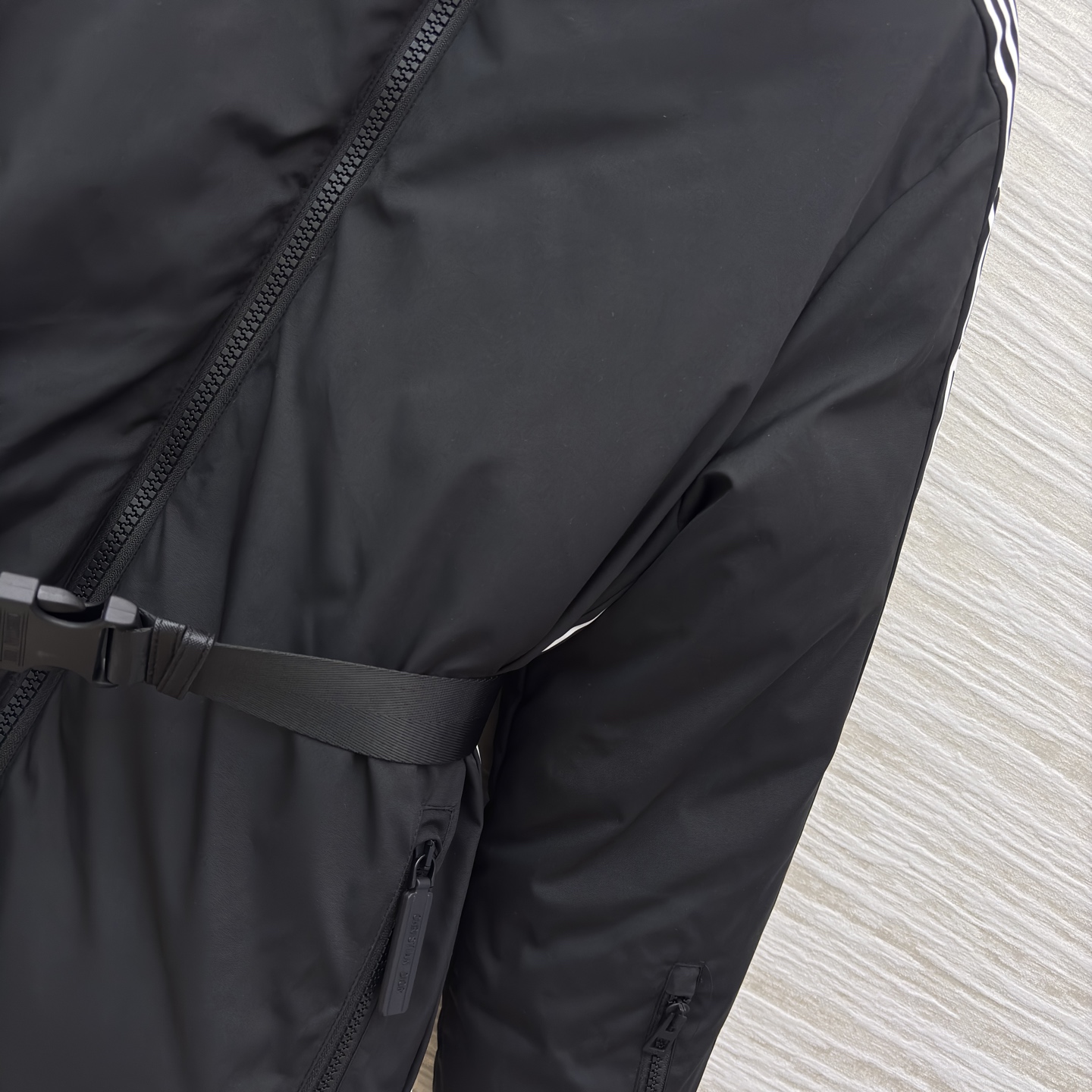 D家 立领收腰羽绒服 是冬日酷感穿搭的首选 立领收腰腰带勾勒利落身形 侧边条纹细节打破纯黑沉闷 蓬松白鸭