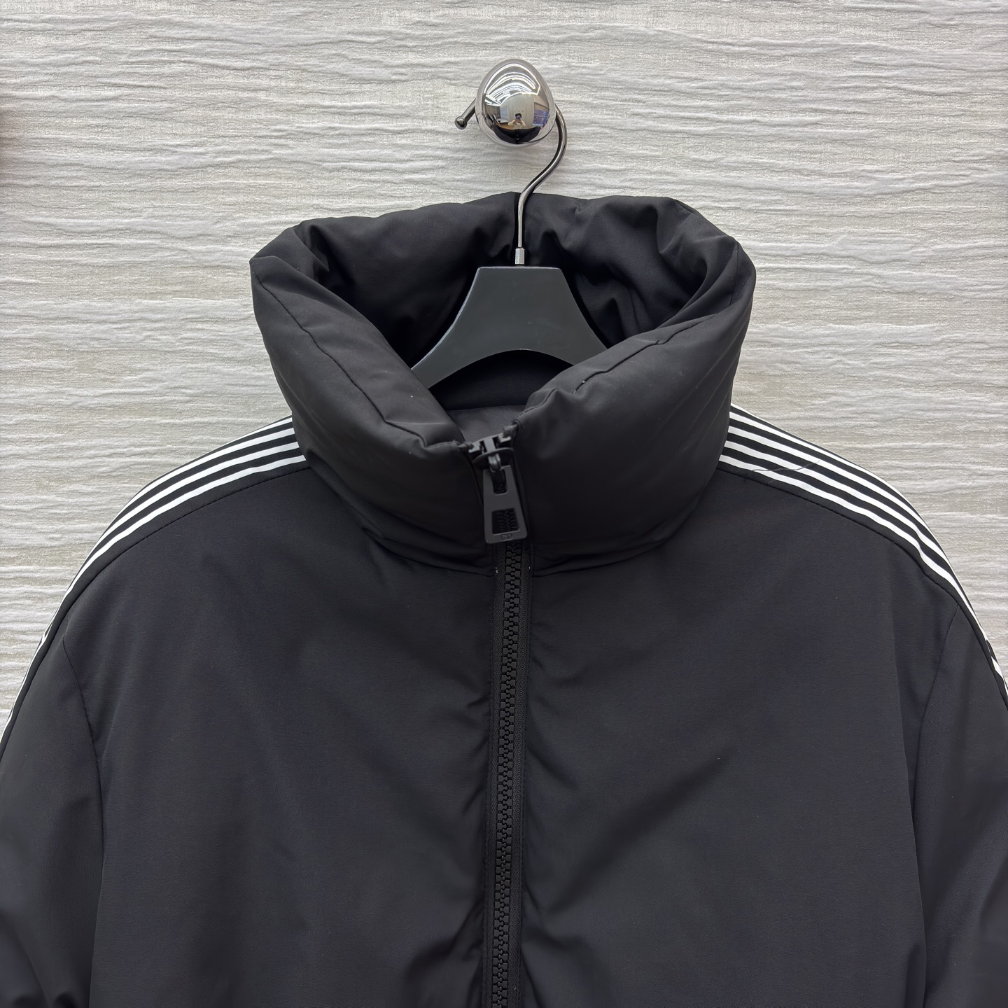 D家 立领收腰羽绒服 是冬日酷感穿搭的首选 立领收腰腰带勾勒利落身形 侧边条纹细节打破纯黑沉闷 蓬松白鸭