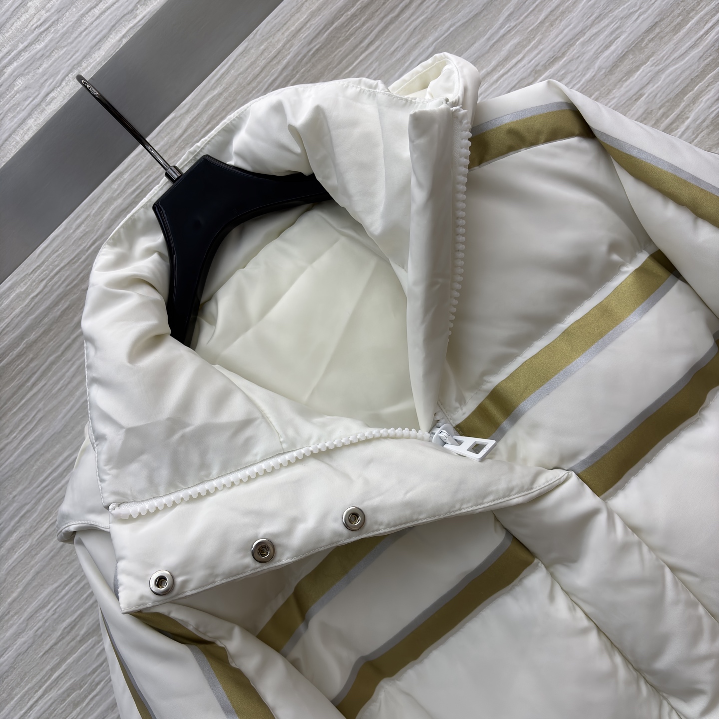 D家 撞色连帽羽绒服 是冬日里的温柔铠甲 米白底色衬出干净氛围 金调条纹与侧边装饰点亮细节 连帽设计裹紧